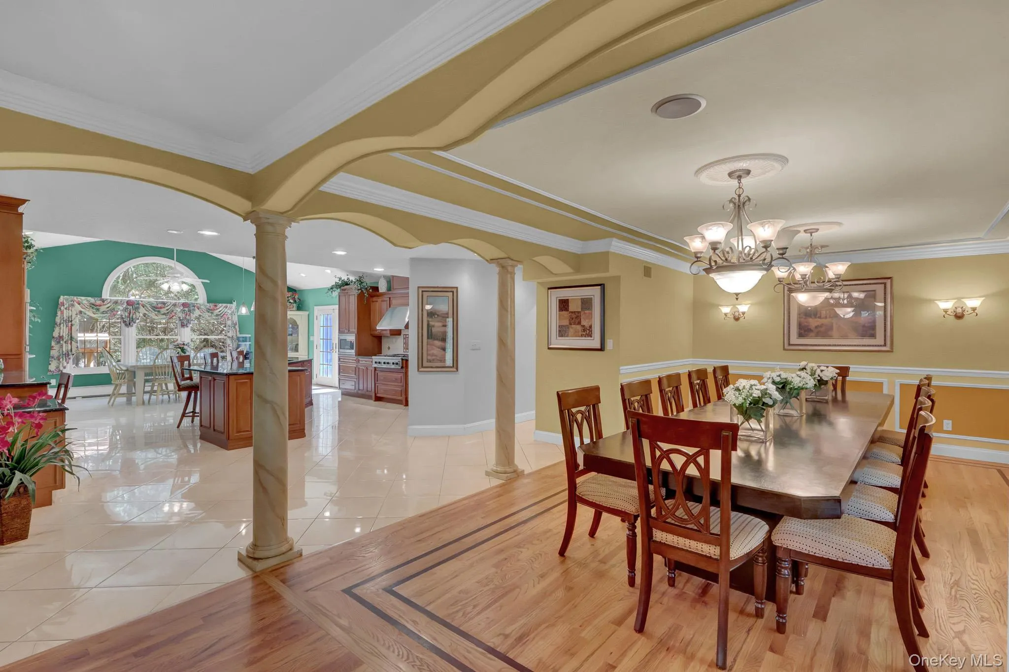 Formal dining room featuring hardwood flooring with a decorative inlay border and a multi-light chandelier Formal dining room featuring hardwood flooring with a decorative inlay border and a multi-light chandelier