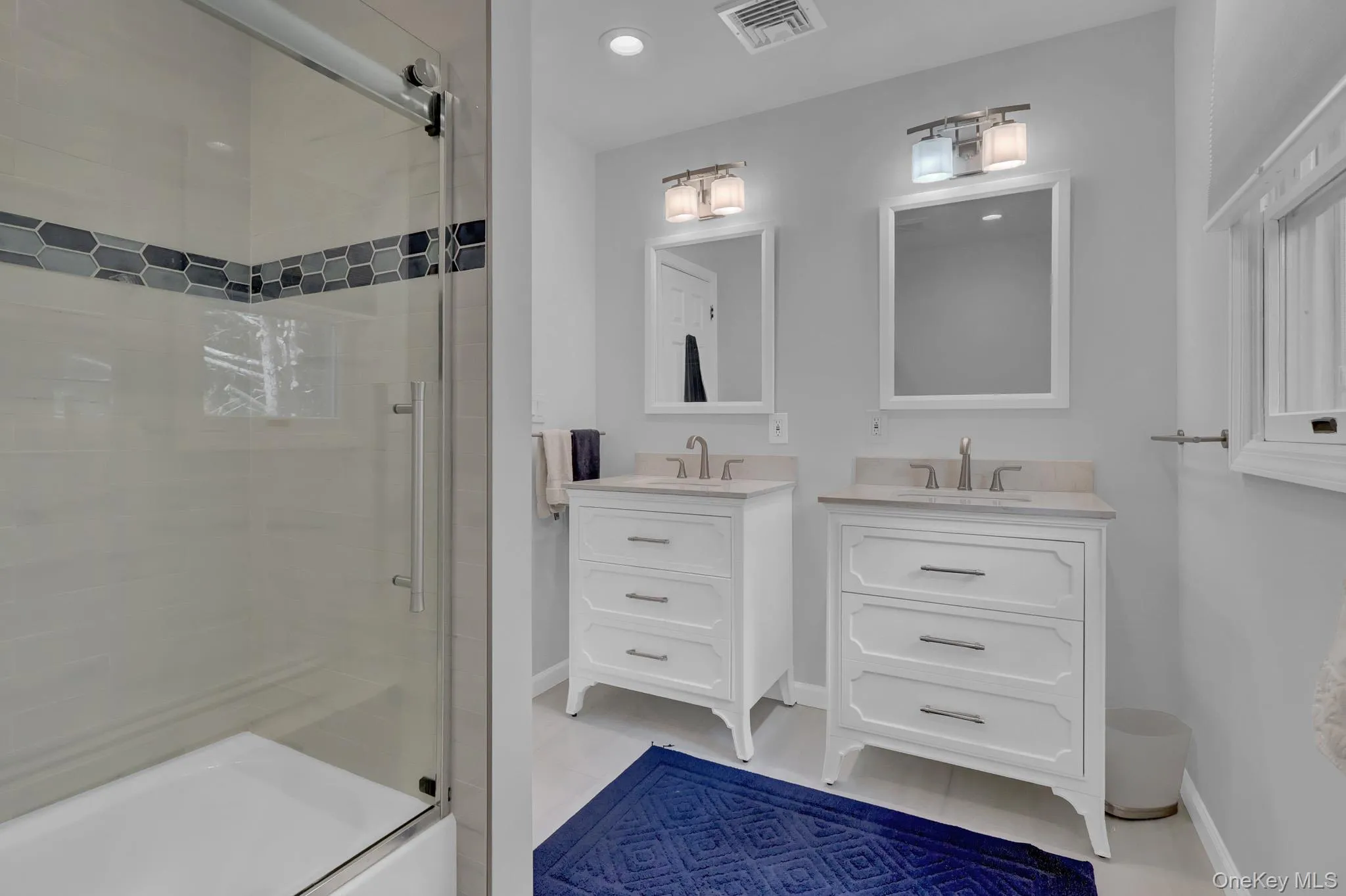 Bathroom featuring a glass-enclosed tub/shower combo with a decorative hexagonal tile accent Bathroom featuring a glass-enclosed tub/shower combo with a decorative hexagonal tile accent