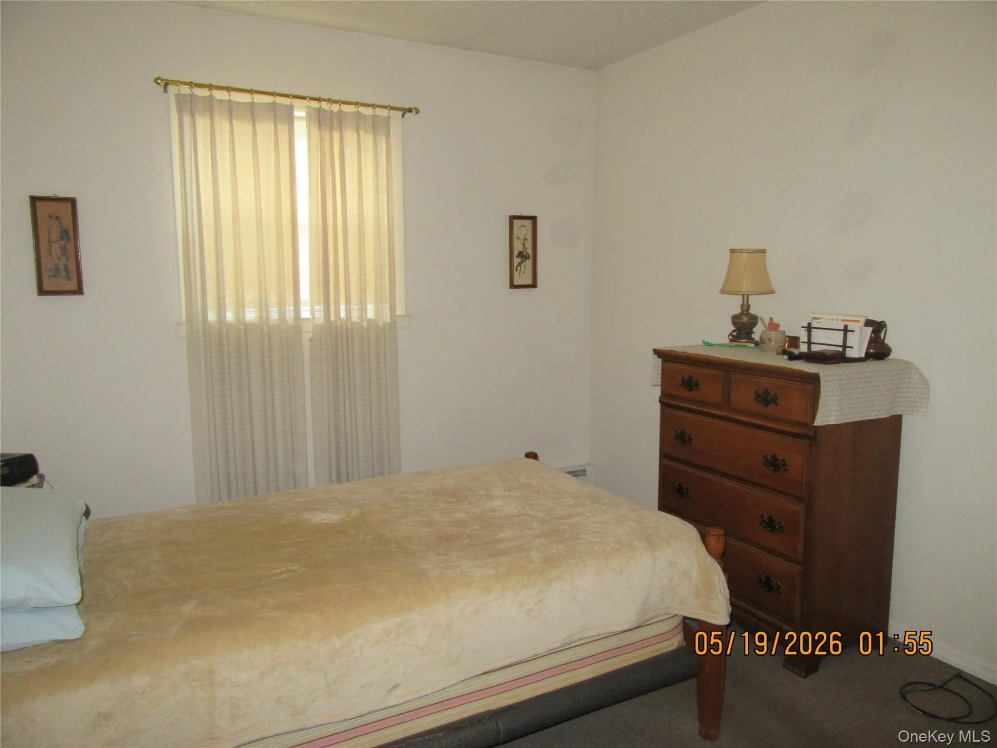 Window with sheer curtains and a gold-toned curtain rod Window with sheer curtains and a gold-toned curtain rod