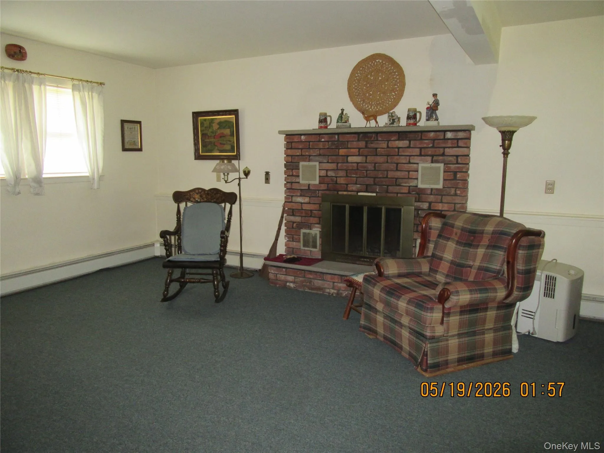 Brick fireplace with a stone mantel and hearth, carpeted flooring, and white painted walls Brick fireplace with a stone mantel and hearth, carpeted flooring, and white painted walls