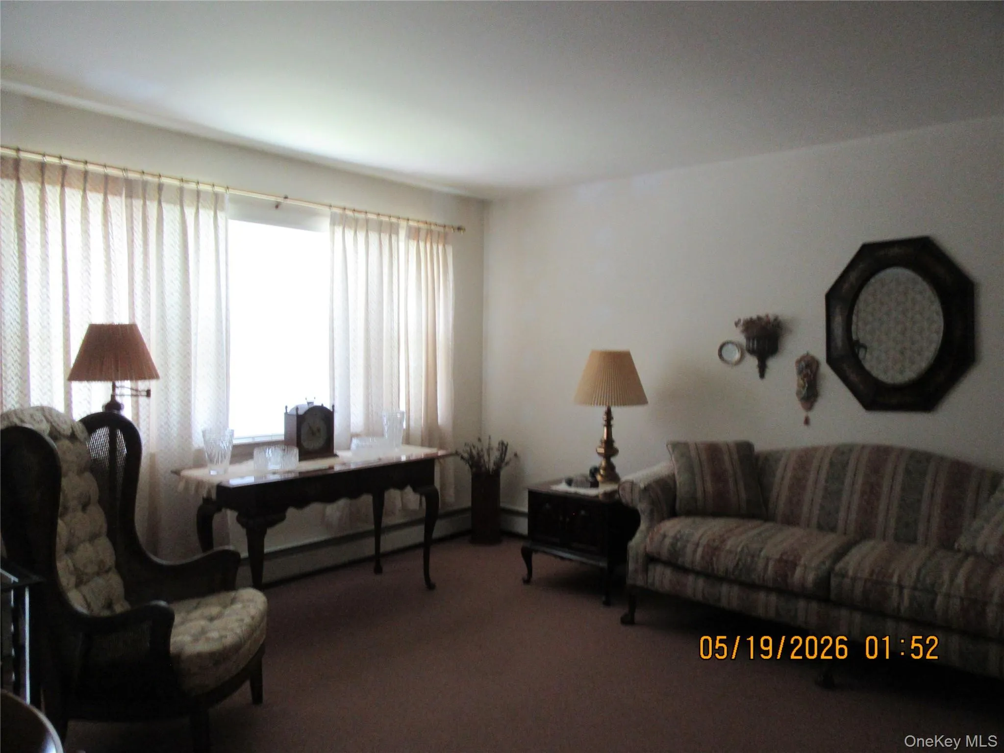 Bright living area featuring a large window with privacy coverings Bright living area featuring a large window with privacy coverings
