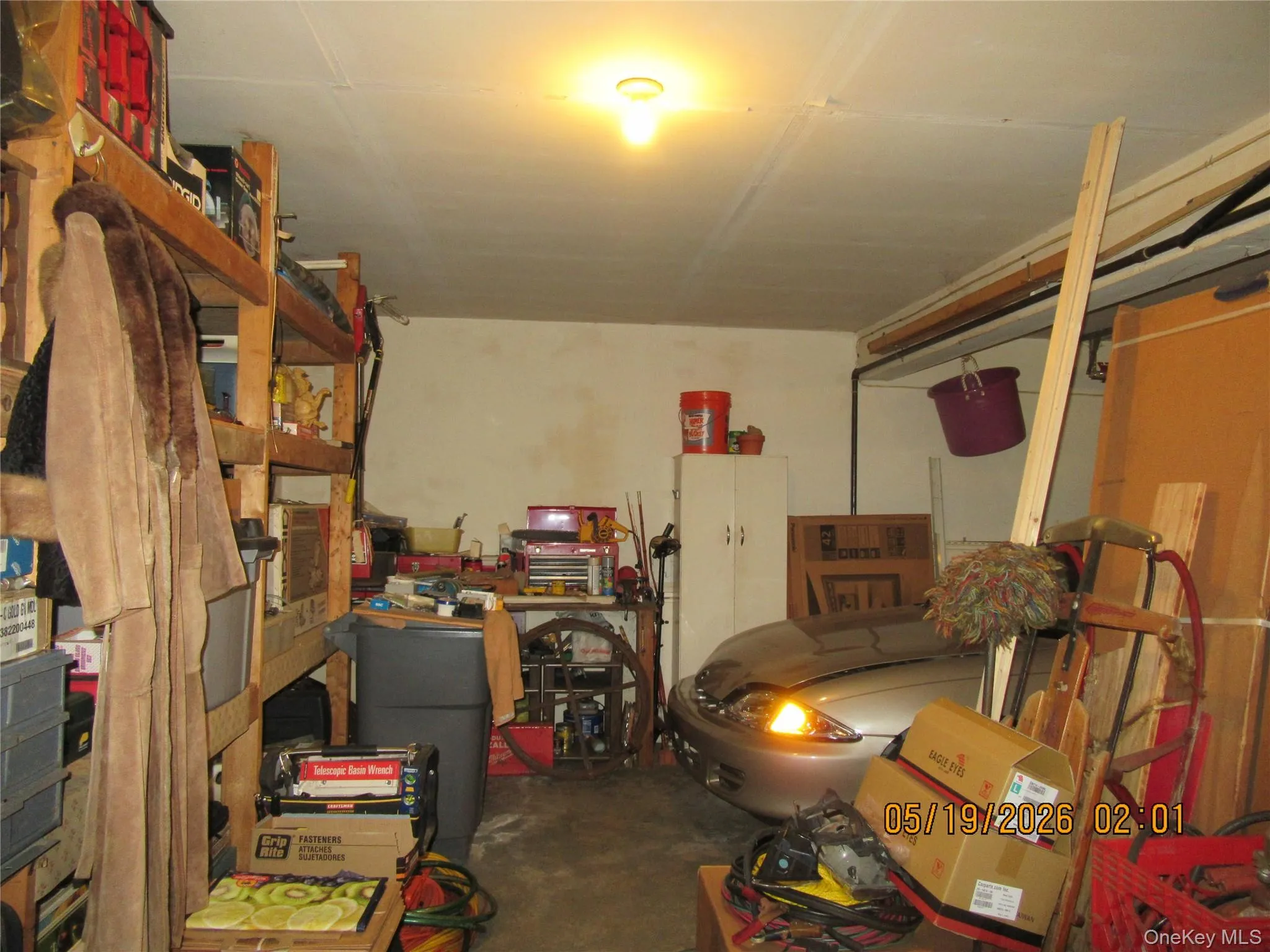 Garage interior featuring concrete flooring, exposed ceiling joists, and overhead lighting Garage interior featuring concrete flooring, exposed ceiling joists, and overhead lighting