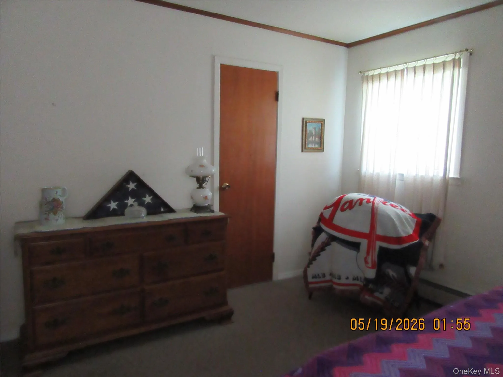Bright room featuring a window with vertical blinds, light-colored walls, and dark wood trim Bright room featuring a window with vertical blinds, light-colored walls, and dark wood trim
