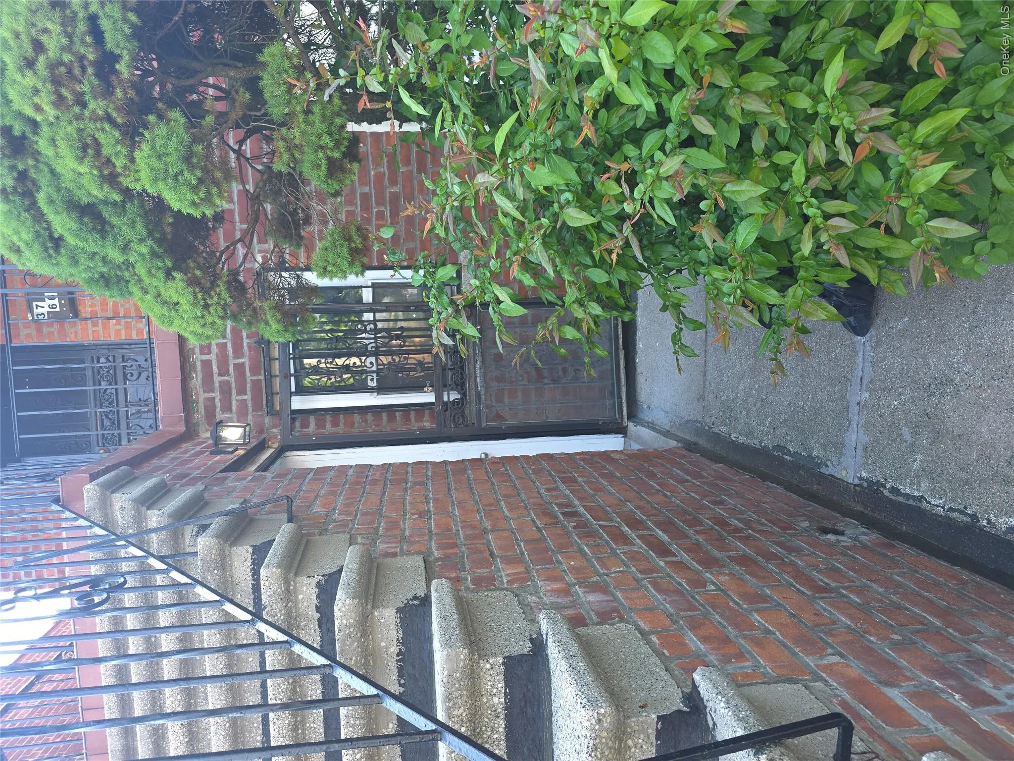 Brick exterior with concrete walkway and steps Brick exterior with concrete walkway and steps