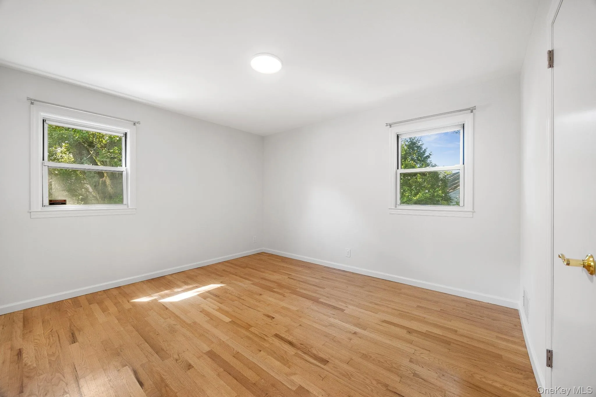 Unfurnished room with light wood-type flooring and baseboards Unfurnished room with light wood-type flooring and baseboards