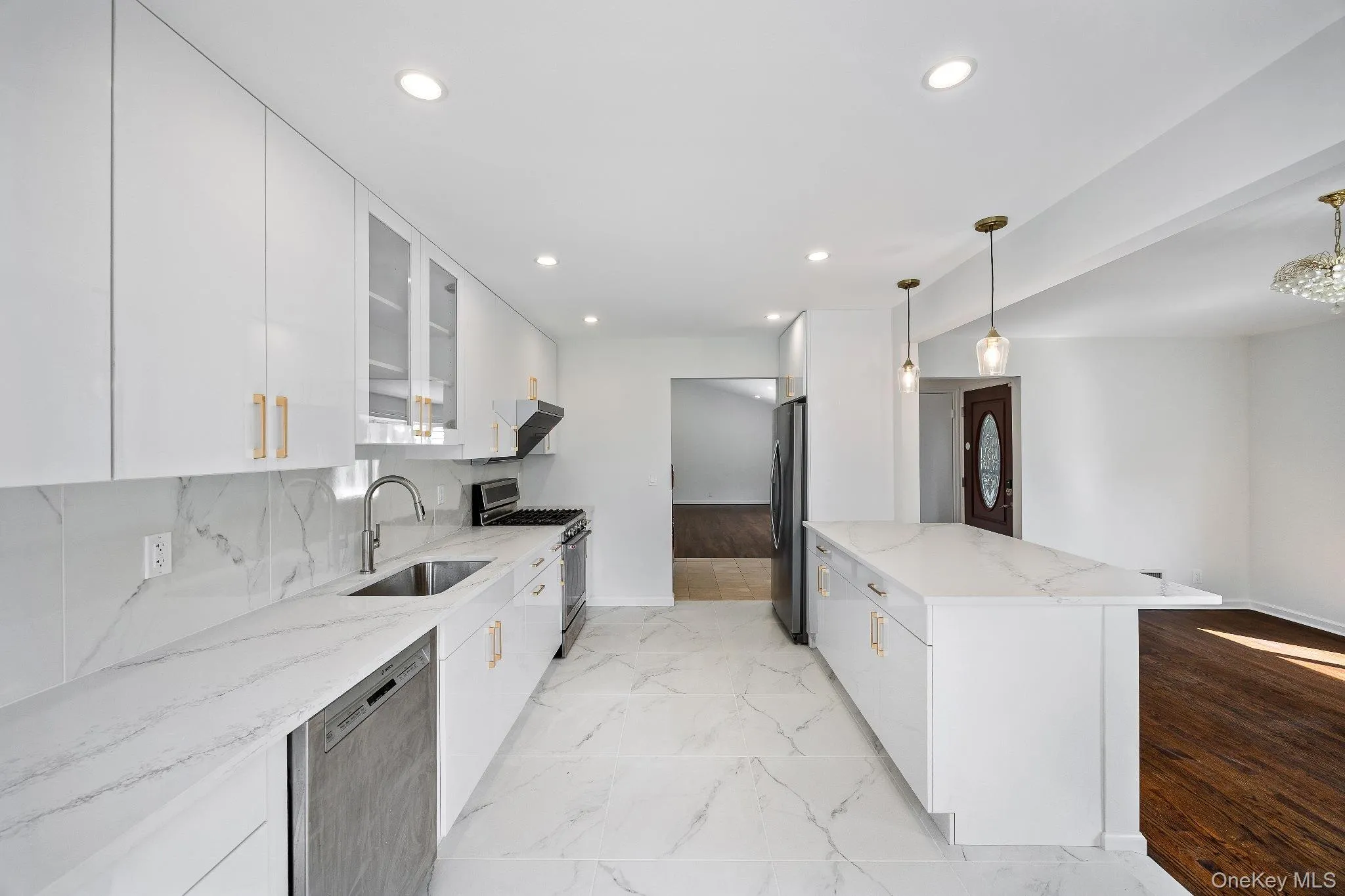Kitchen featuring glass insert cabinets, light stone countertops, white cabinetry, stainless steel appliances, and backsplash Kitchen featuring glass insert cabinets, light stone countertops, white cabinetry, stainless steel appliances, and backsplash