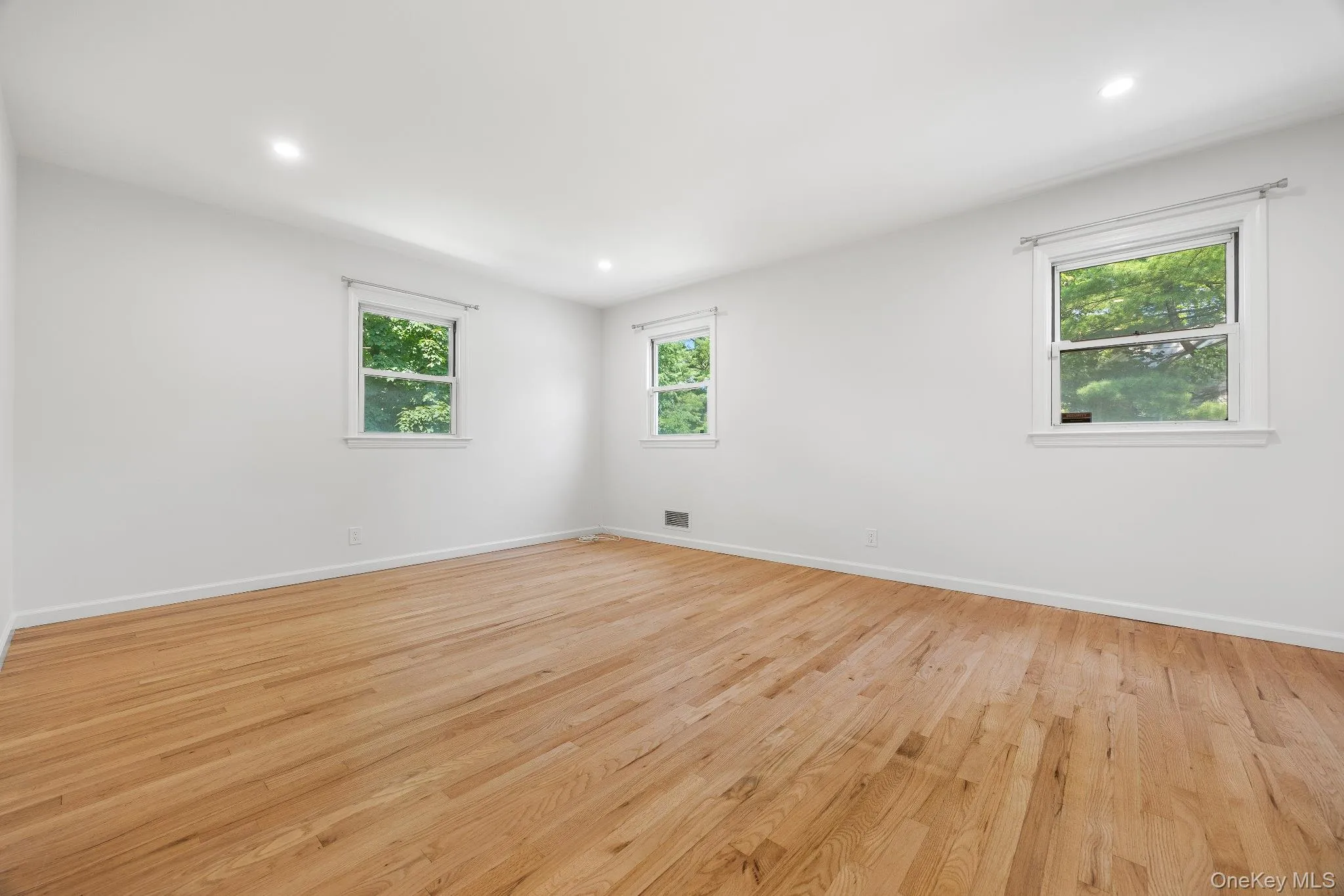 Empty room with light wood-style floors and recessed lighting Empty room with light wood-style floors and recessed lighting