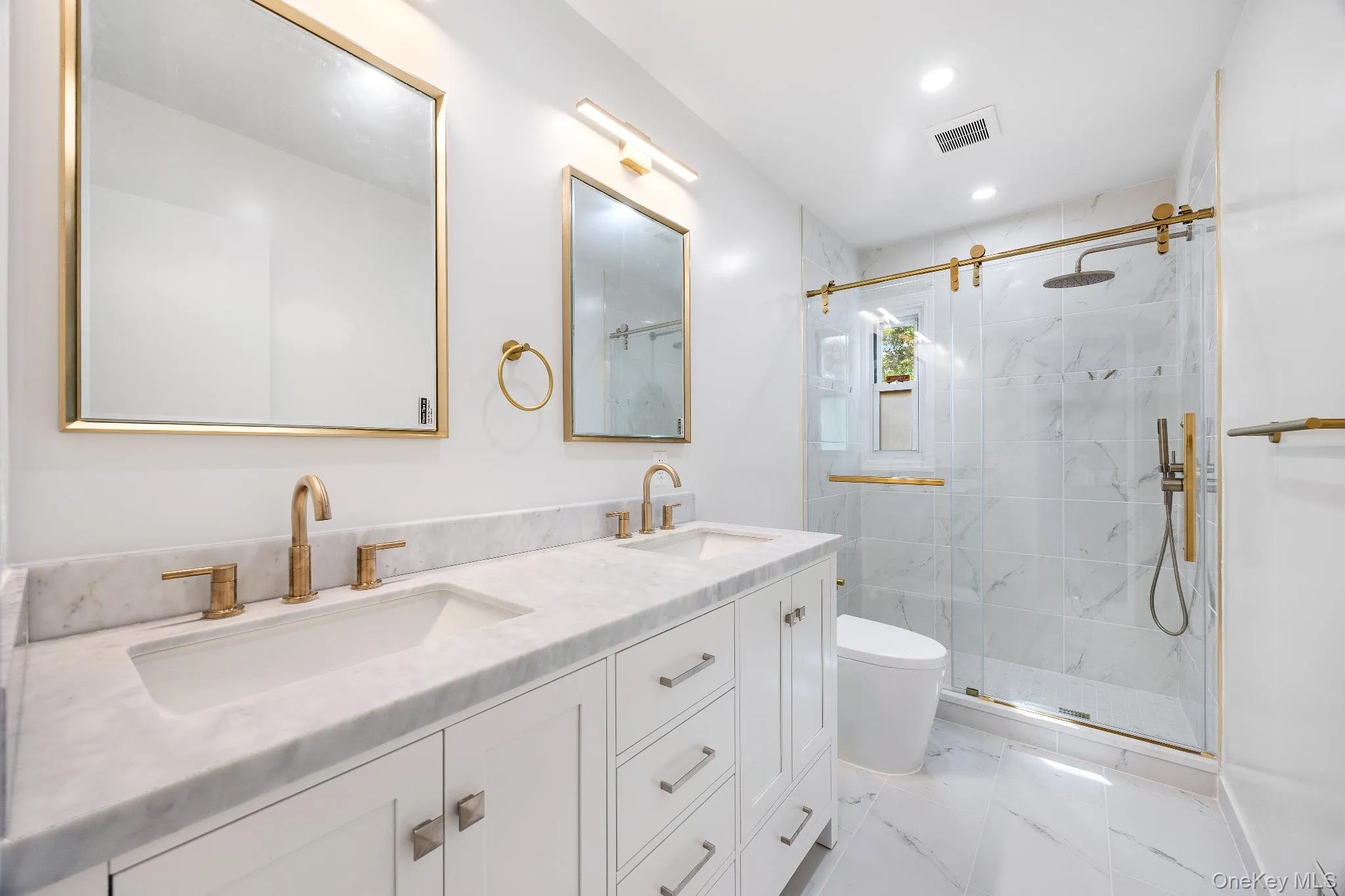 Full bath with a marble finish shower, double vanity, light marble finish flooring, and recessed lighting Full bath with a marble finish shower, double vanity, light marble finish flooring, and recessed lighting