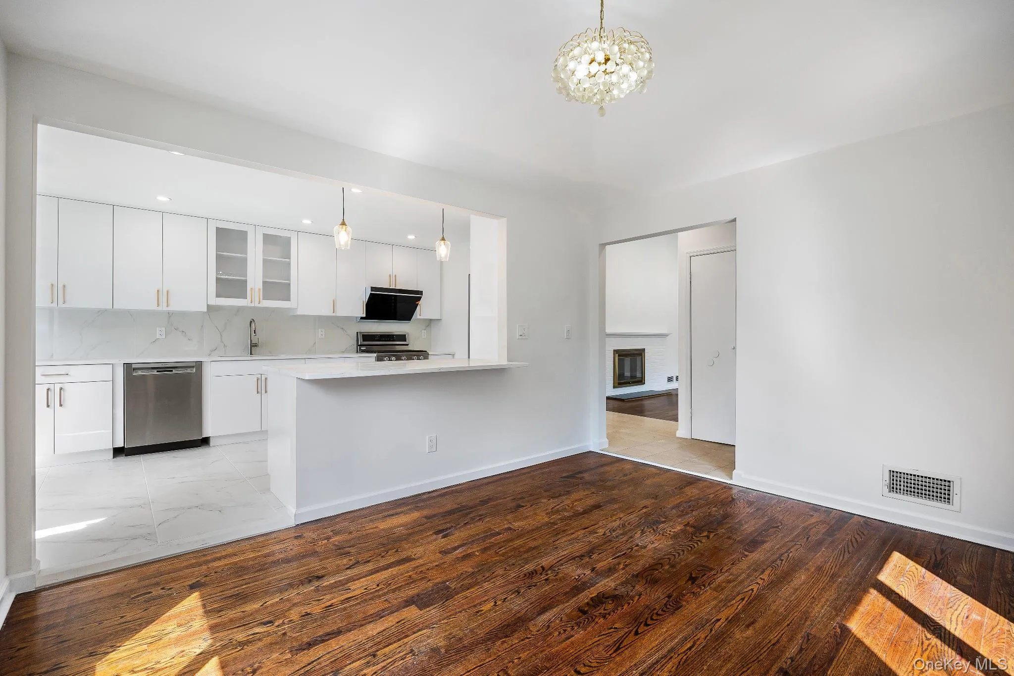 Kitchen with white cabinets, glass insert cabinets, tasteful backsplash, and pendant lighting Kitchen with white cabinets, glass insert cabinets, tasteful backsplash, and pendant lighting