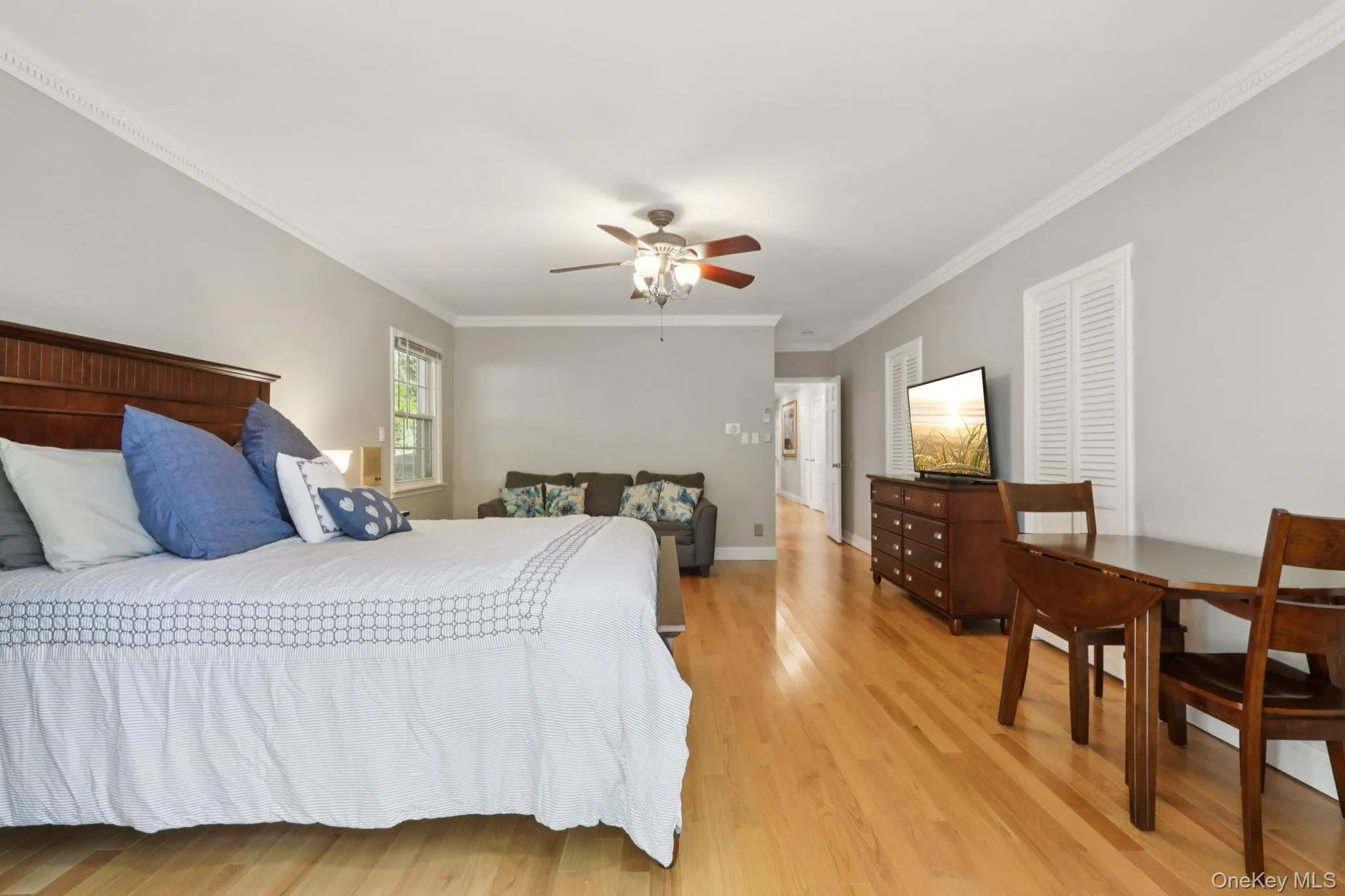 Bedroom featuring crown molding, light wood-style floors, and a ceiling fan Bedroom featuring crown molding, light wood-style floors, and a ceiling fan