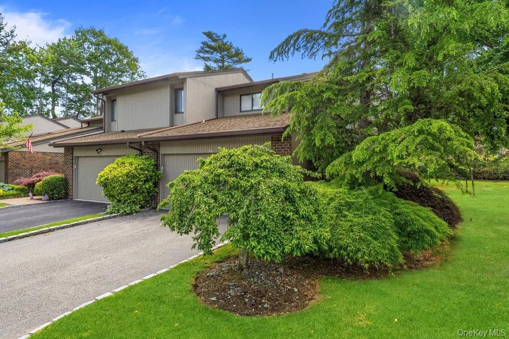 Exterior featuring a sloped roofline, attached garage, and a paved driveway Exterior featuring a sloped roofline, attached garage, and a paved driveway