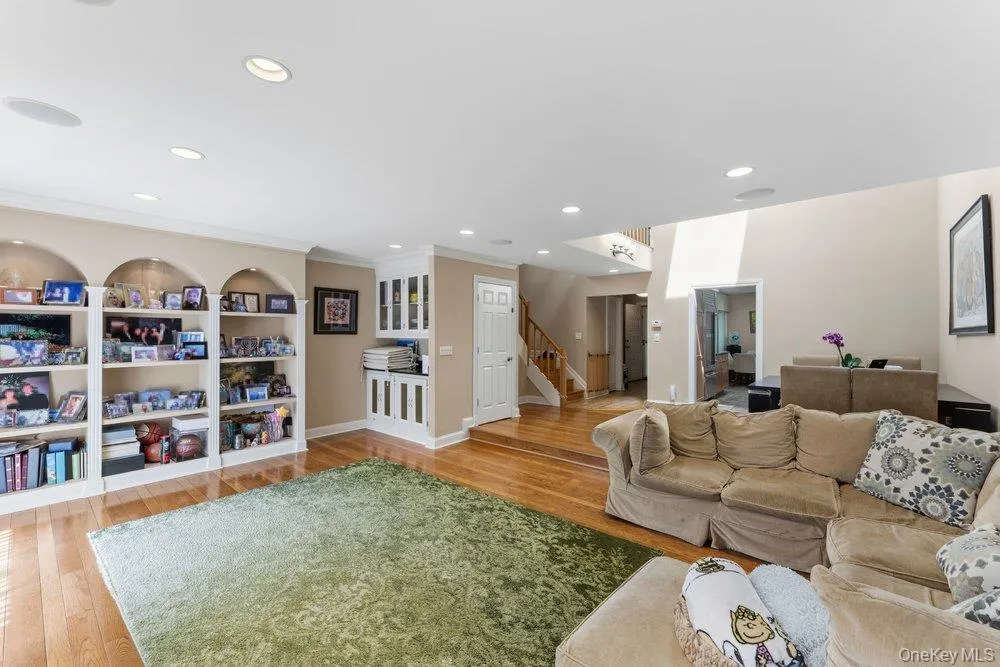 Living area featuring wood-finish flooring, recessed lighting, and integrated ceiling speakers Living area featuring wood-finish flooring, recessed lighting, and integrated ceiling speakers