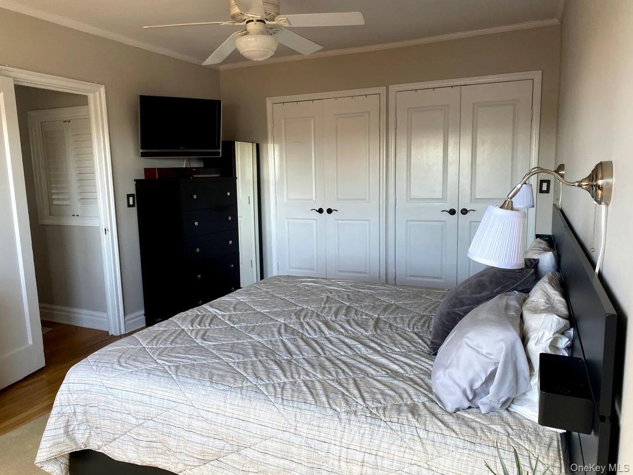 Bedroom with two closets, baseboards, crown molding, and wood finished floors Bedroom with two closets, baseboards, crown molding, and wood finished floors