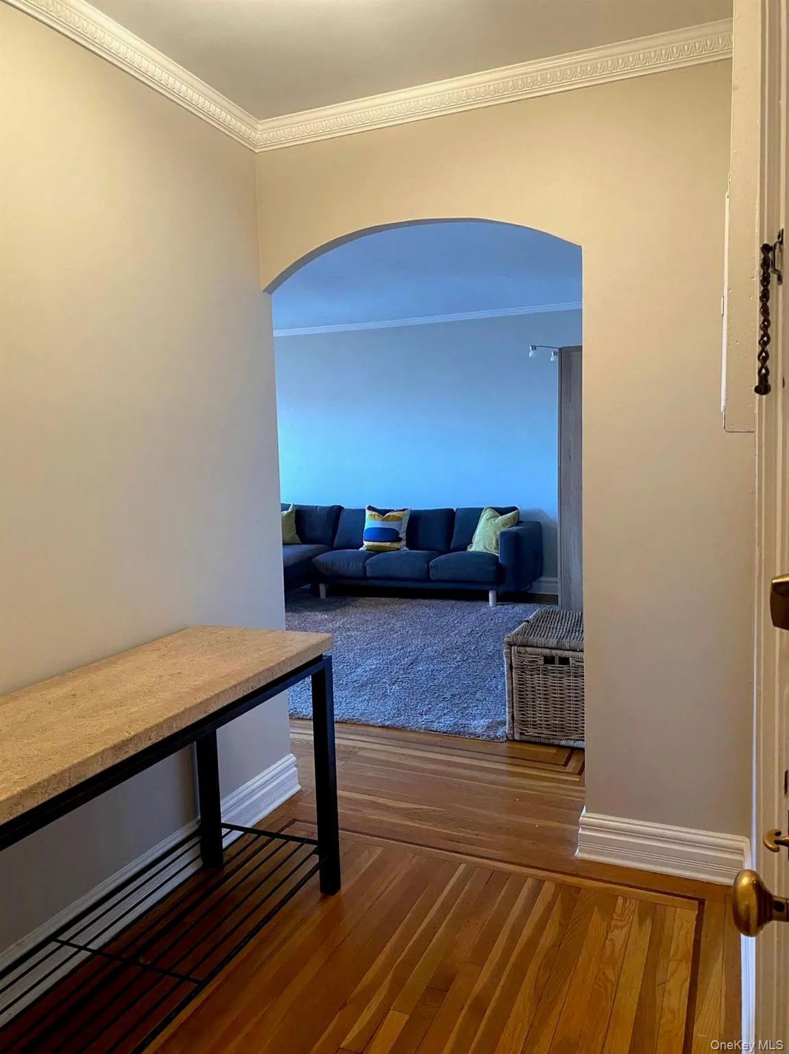 Corridor with arched walkways, wood finished floors, baseboards, and ornamental molding Corridor with arched walkways, wood finished floors, baseboards, and ornamental molding