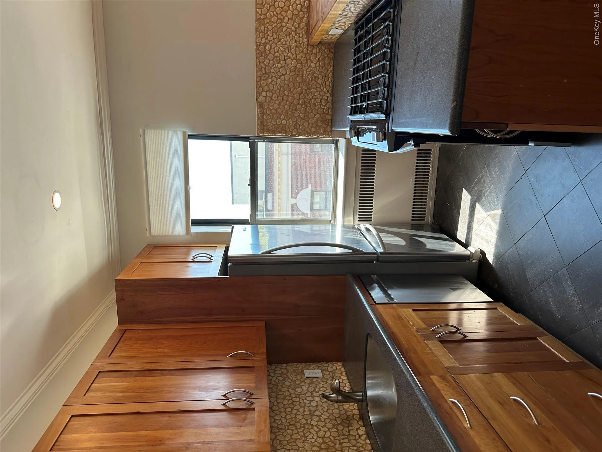 Kitchen featuring radiator heating unit, a sink, dishwasher, stove, and freestanding refrigerator Kitchen featuring radiator heating unit, a sink, dishwasher, stove, and freestanding refrigerator