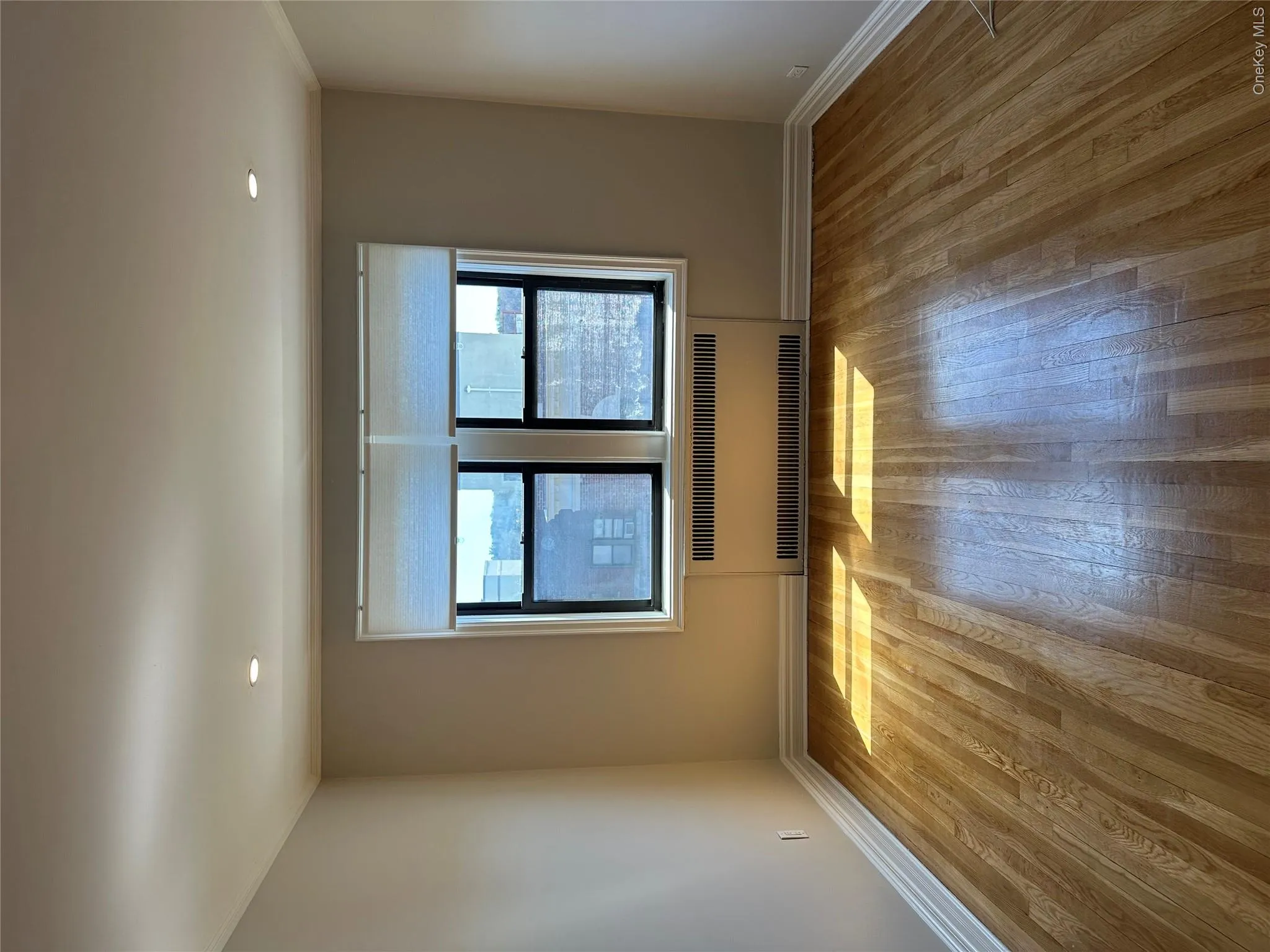 Spare room with radiator, recessed lighting, wood finished floors, crown molding, and baseboards Spare room with radiator, recessed lighting, wood finished floors, crown molding, and baseboards