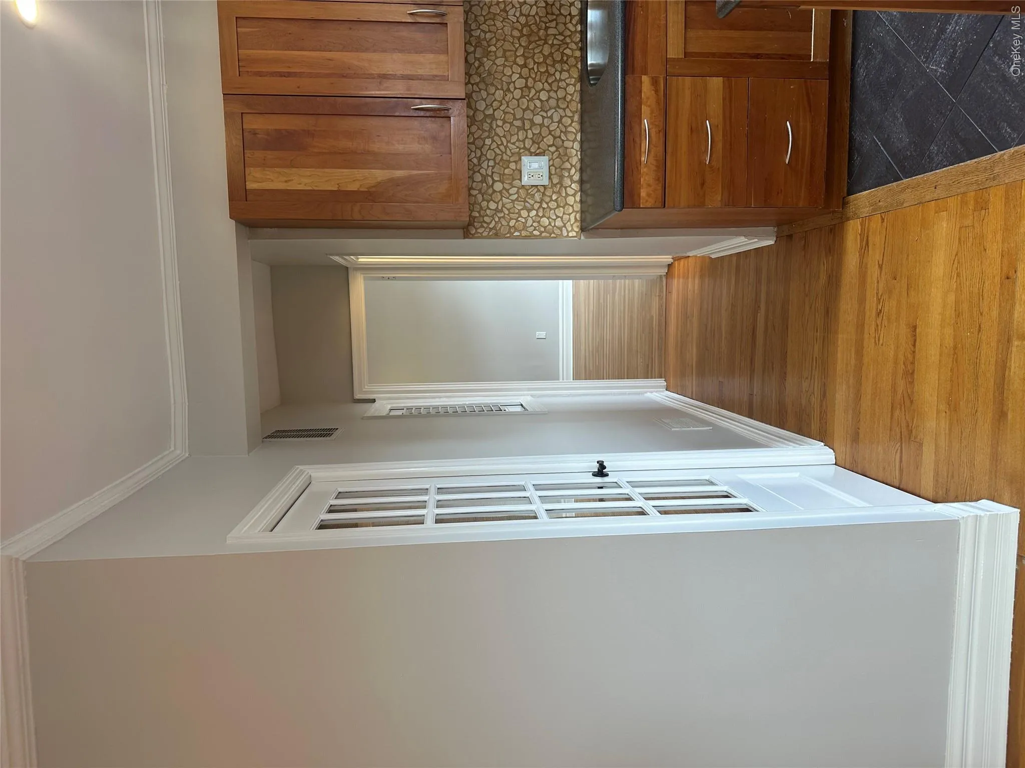 Hall featuring a sink, dark wood finished floors, baseboards, ornamental molding, and visible vents Hall featuring a sink, dark wood finished floors, baseboards, ornamental molding, and visible vents