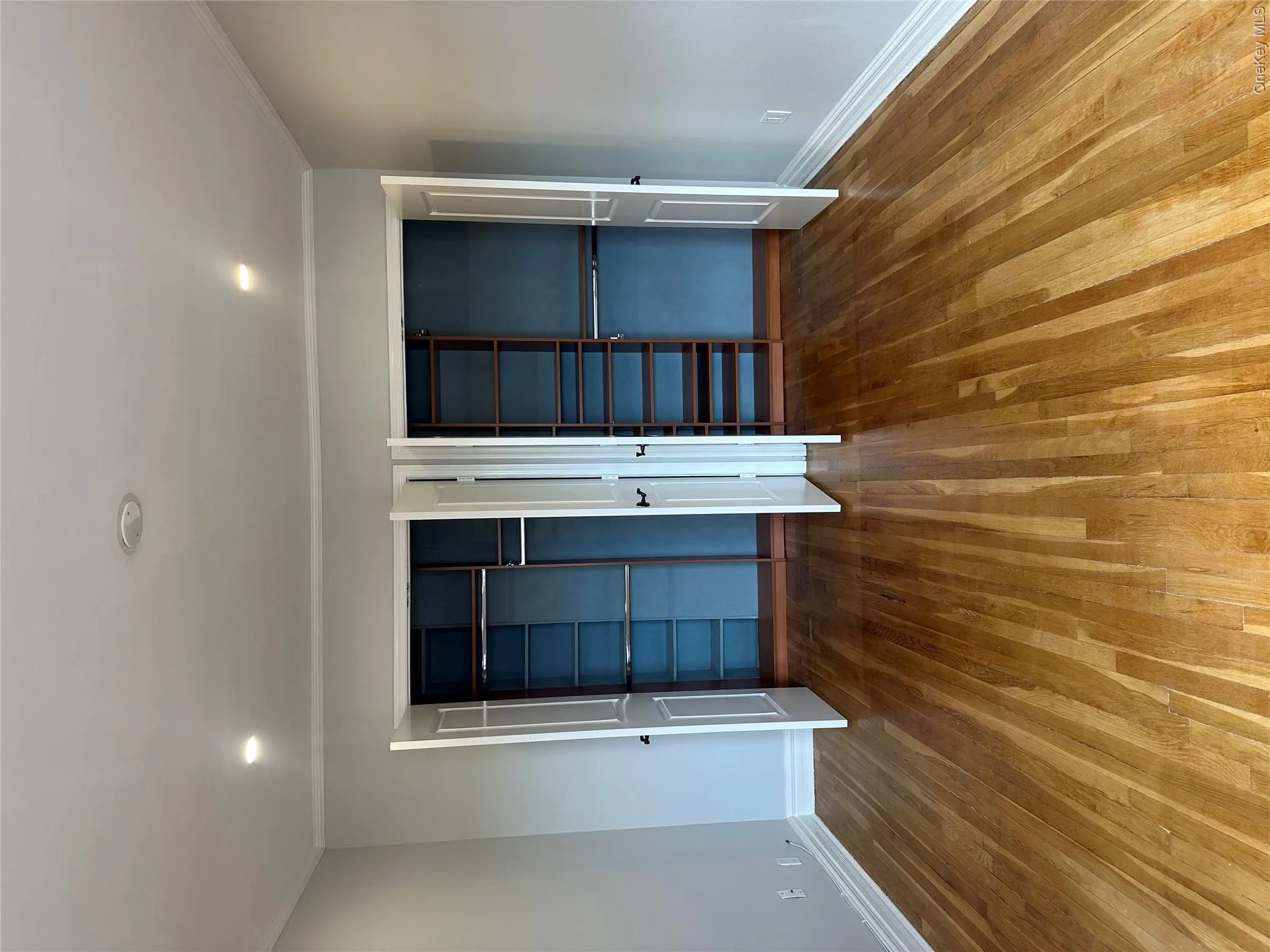 Unfurnished bedroom featuring baseboards, wood finished floors, and multiple closets Unfurnished bedroom featuring baseboards, wood finished floors, and multiple closets