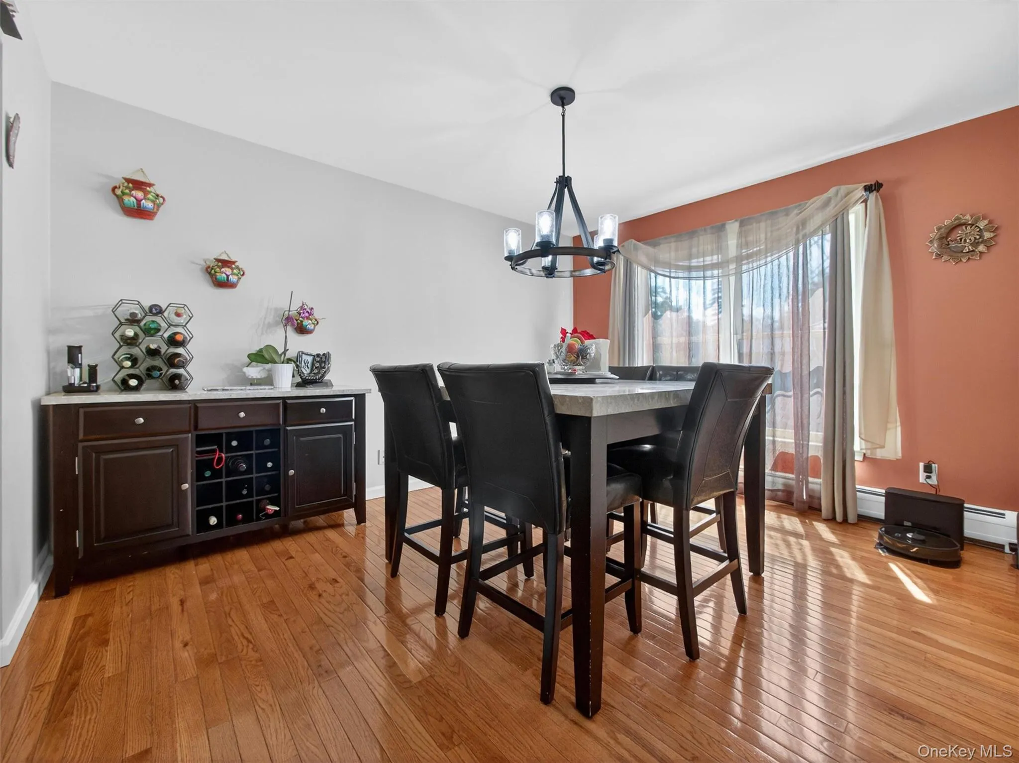Formal dining room featuring hardwood floors, natural light, and an inviting space for gatherings and entertaining. Formal dining room featuring hardwood floors, natural light, and an inviting space for gatherings and entertaining.