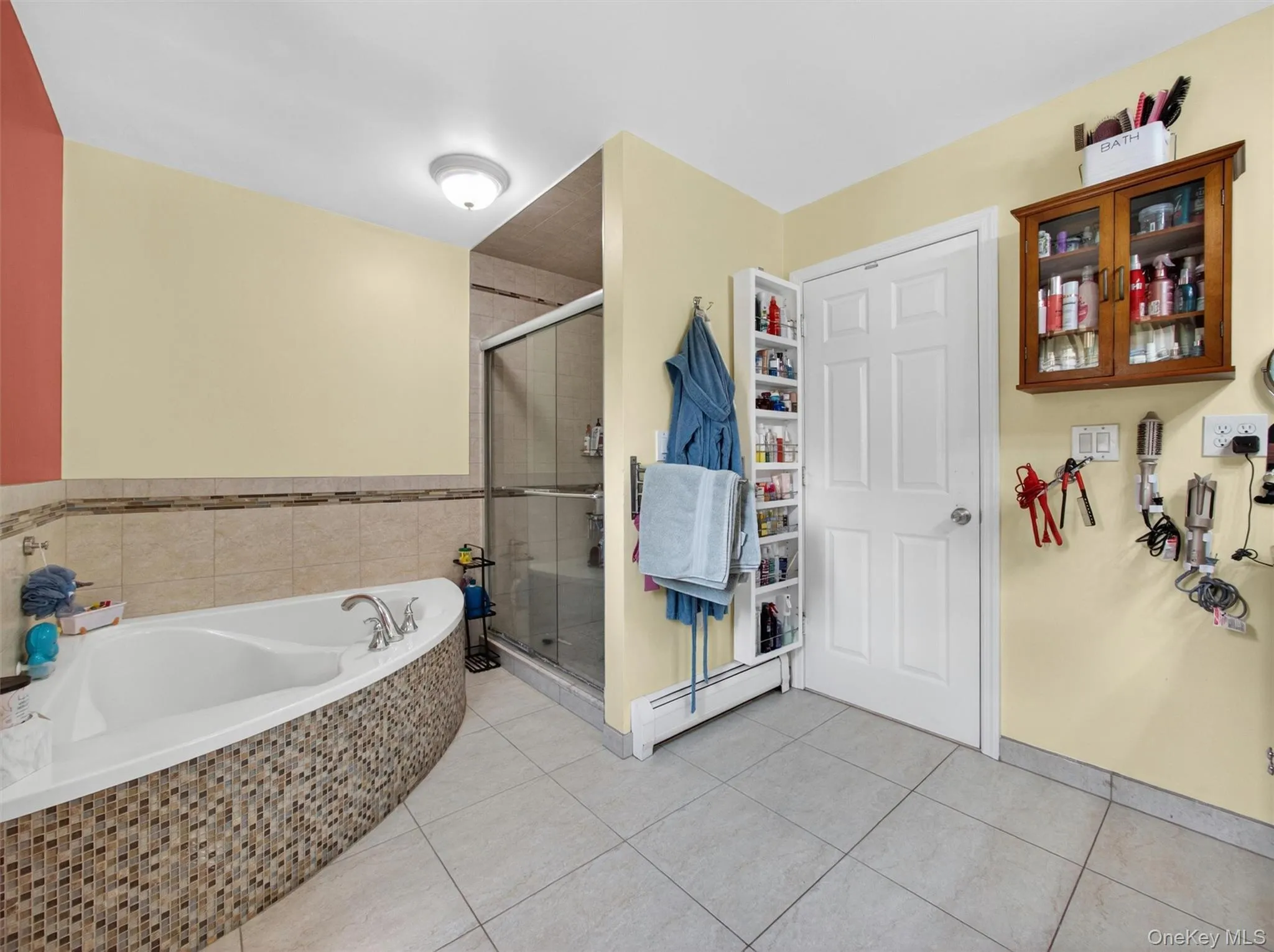 Large primary bathroom with soaking tub, separate shower area, and a functional open layout. Large primary bathroom with soaking tub, separate shower area, and a functional open layout.