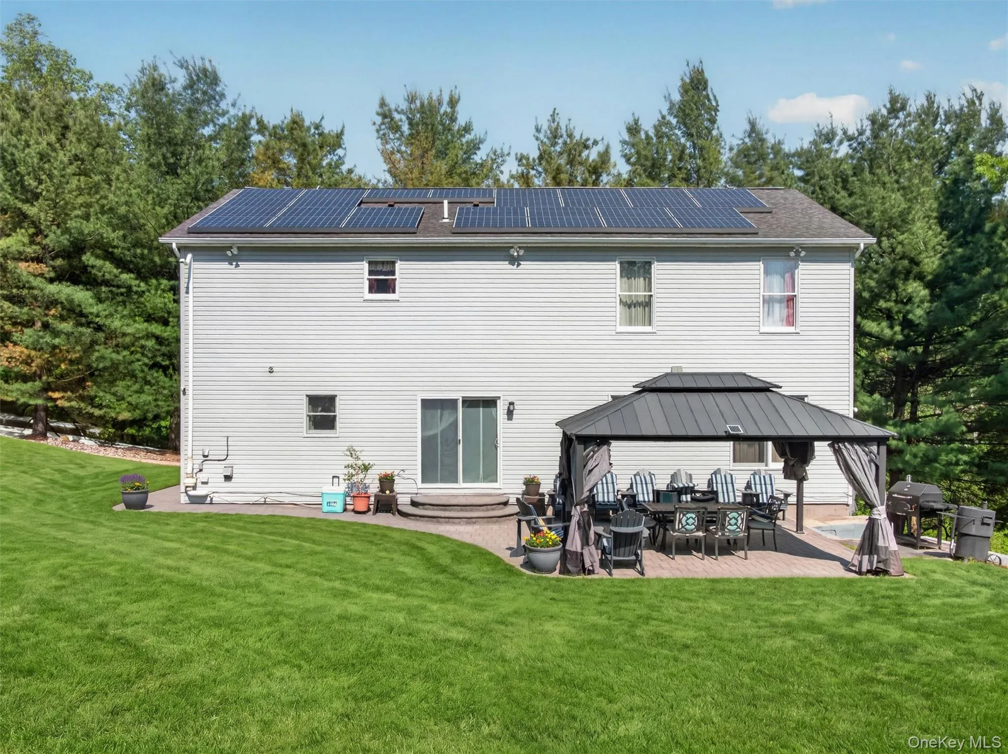 Rear exterior showcasing the spacious backyard, outdoor entertaining area, and beautiful property setting. Rear exterior showcasing the spacious backyard, outdoor entertaining area, and beautiful property setting.