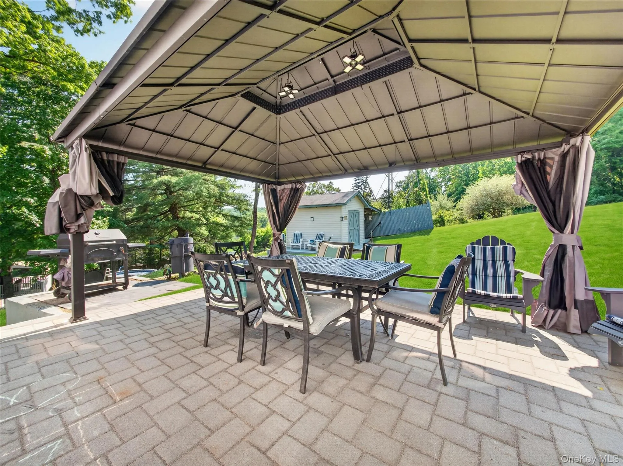 Covered outdoor entertaining area featuring a spacious paver patio and relaxing gathering space. Covered outdoor entertaining area featuring a spacious paver patio and relaxing gathering space.