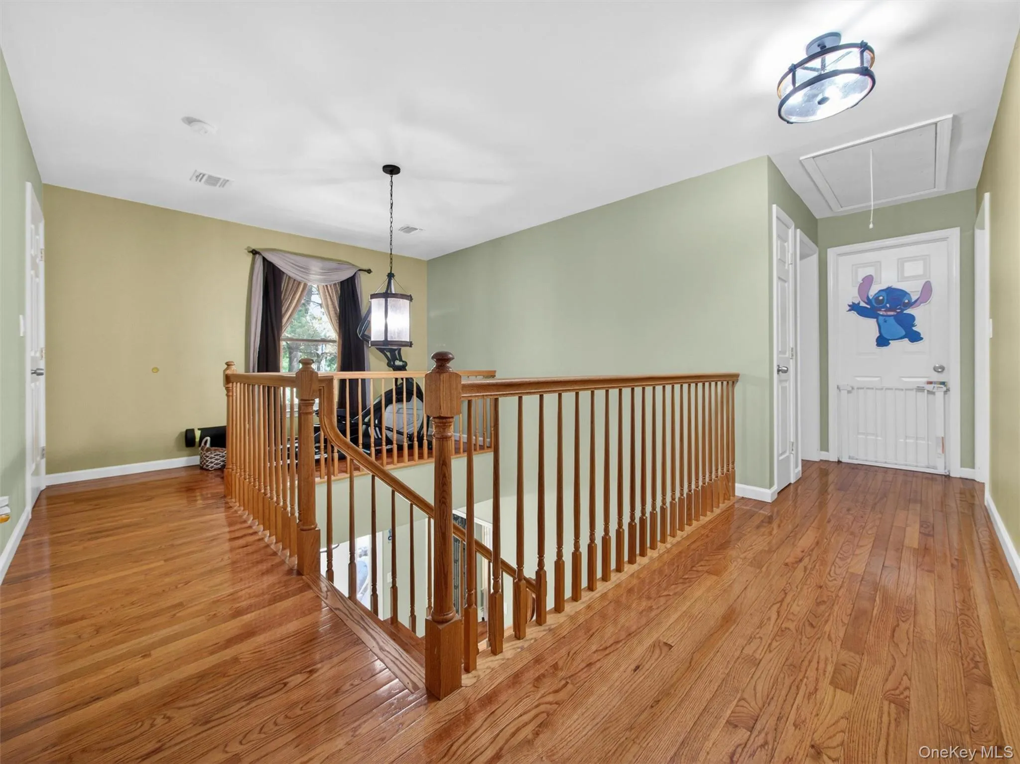 Open second-floor foyer featuring hardwood floors, railing overlook to the main entry, and flexible upper-level living space. Open second-floor foyer featuring hardwood floors, railing overlook to the main entry, and flexible upper-level living space.