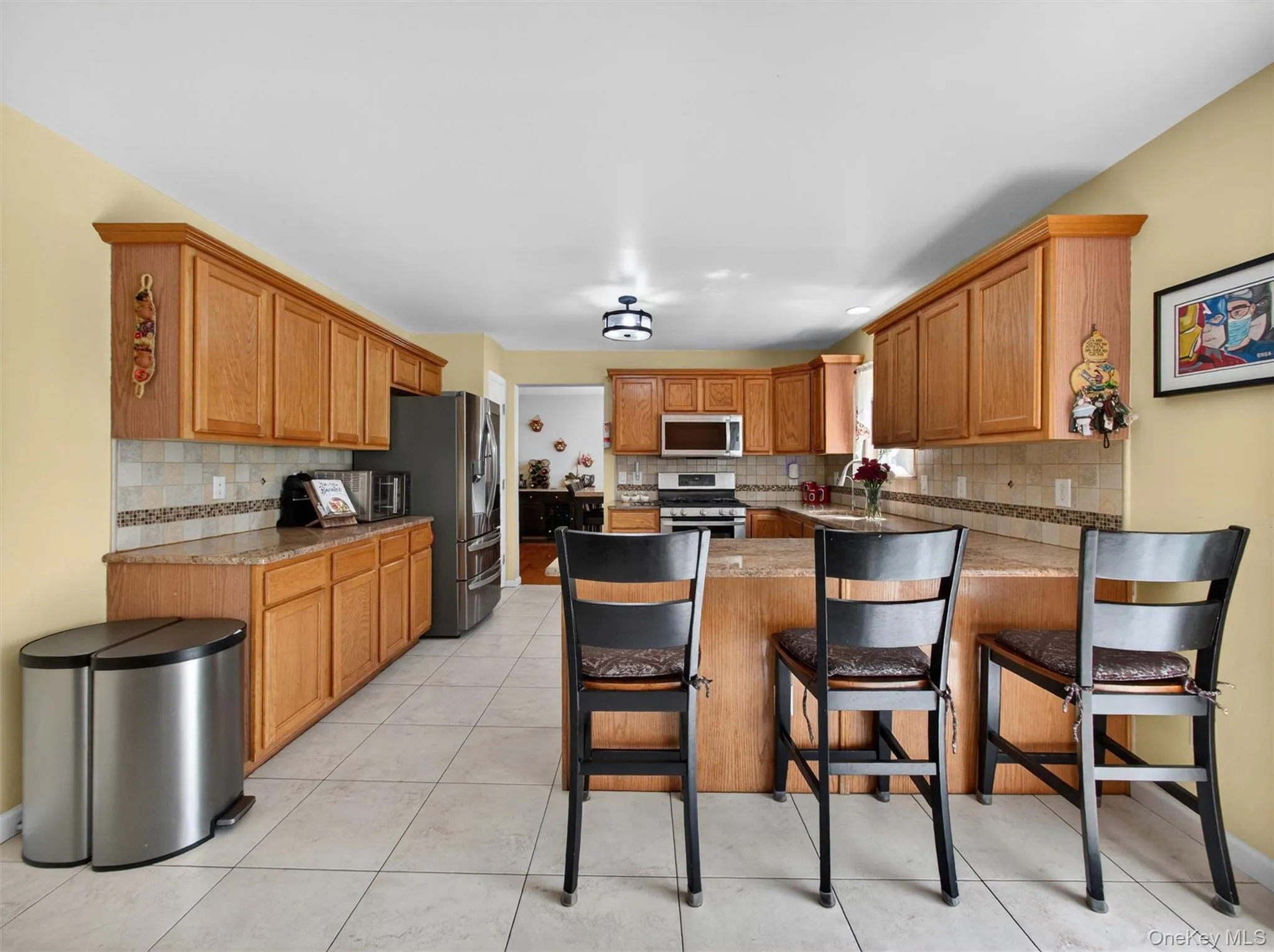 Large kitchen featuring abundant cabinetry, center island seating, and an open layout ideal for entertaining. Large kitchen featuring abundant cabinetry, center island seating, and an open layout ideal for entertaining.
