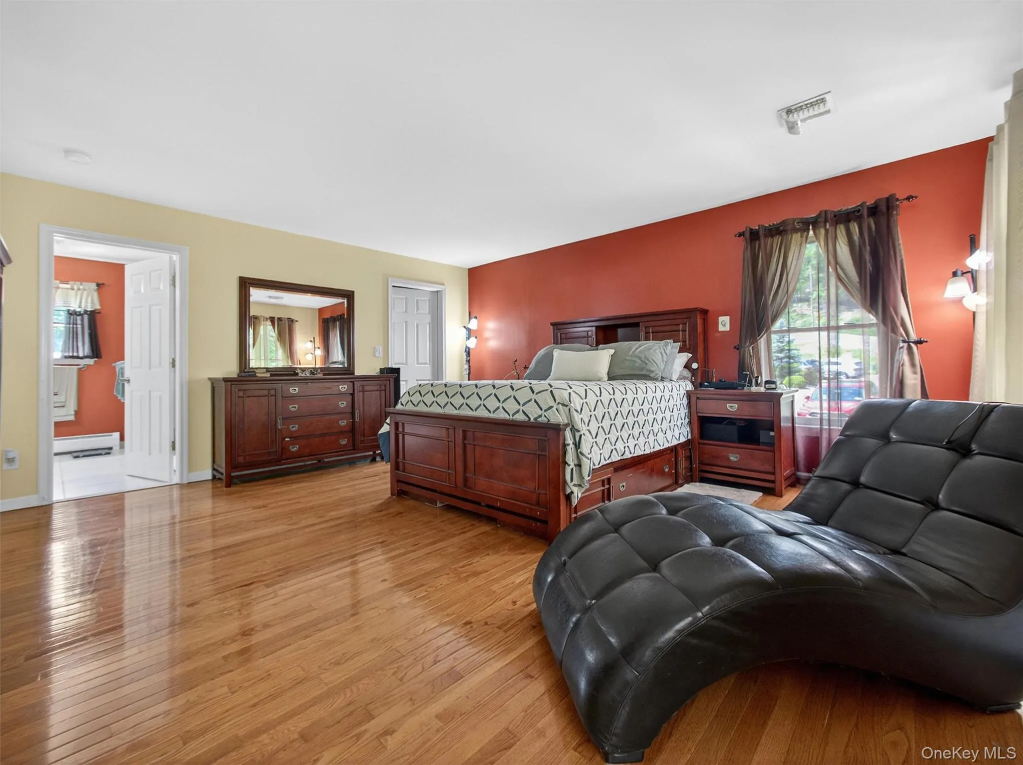Spacious primary bedroom featuring hardwood floors, large windows, and abundant natural light. Spacious primary bedroom featuring hardwood floors, large windows, and abundant natural light.
