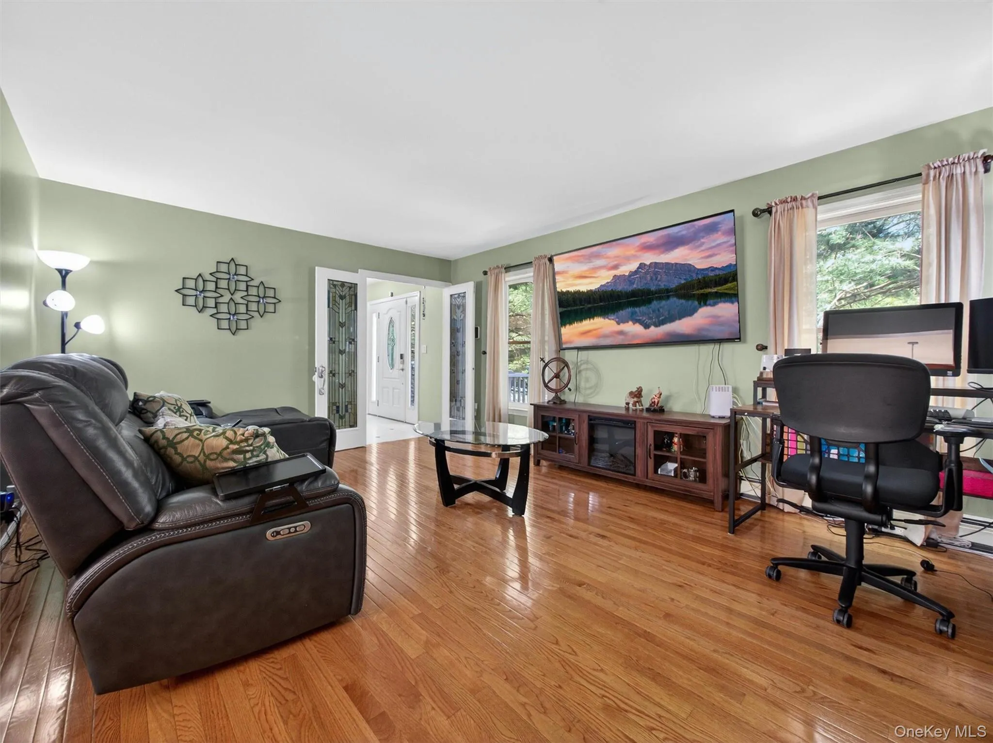 Bright and spacious living room featuring hardwood floors, large windows, and abundant natural light. Bright and spacious living room featuring hardwood floors, large windows, and abundant natural light.