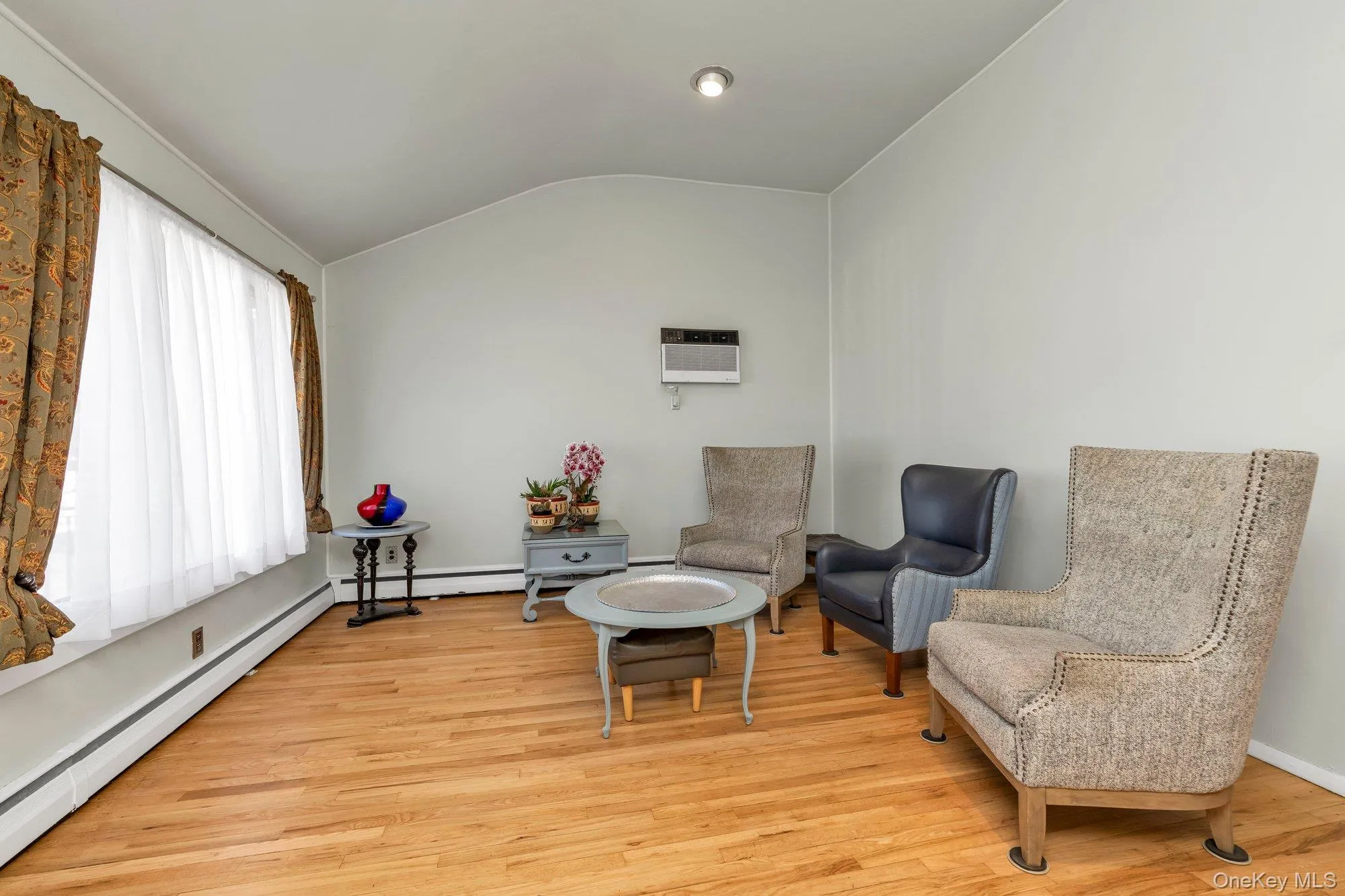 Living area featuring wood-finish flooring, a vaulted ceiling, and recessed lighting Living area featuring wood-finish flooring, a vaulted ceiling, and recessed lighting