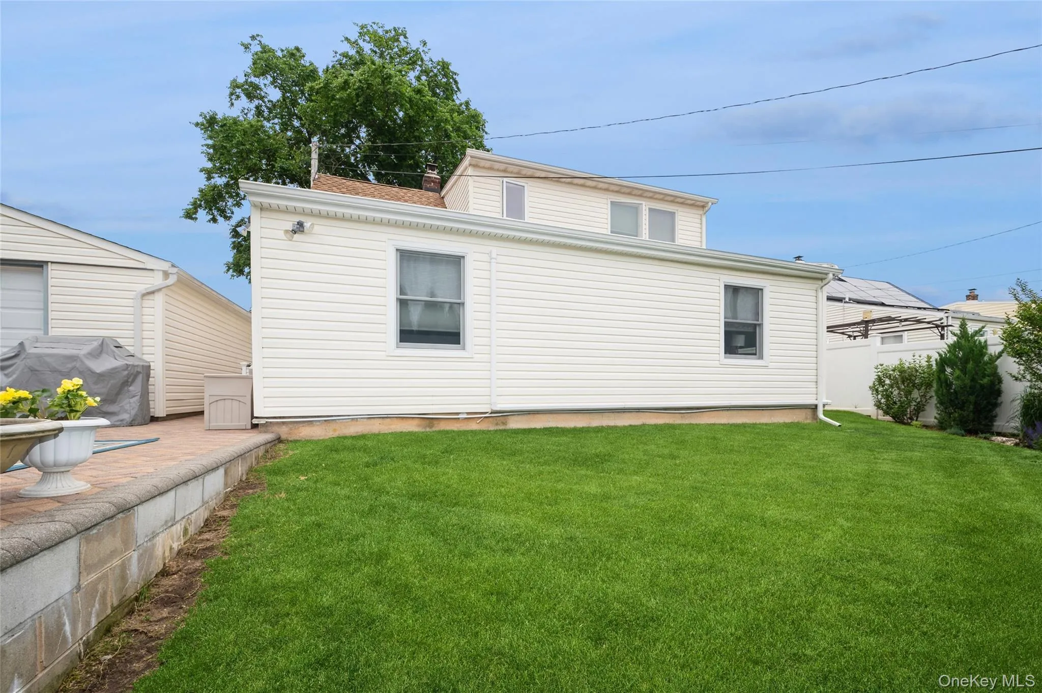 Expansive green lawn with a white vinyl-sided exterior and white window frames Expansive green lawn with a white vinyl-sided exterior and white window frames