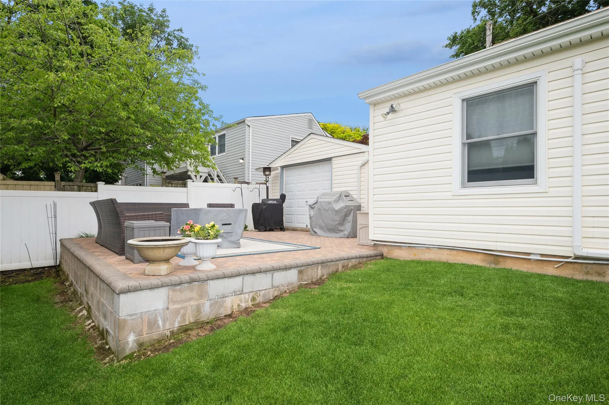 Level patio overlooking sloping lush lawn Level patio overlooking sloping lush lawn