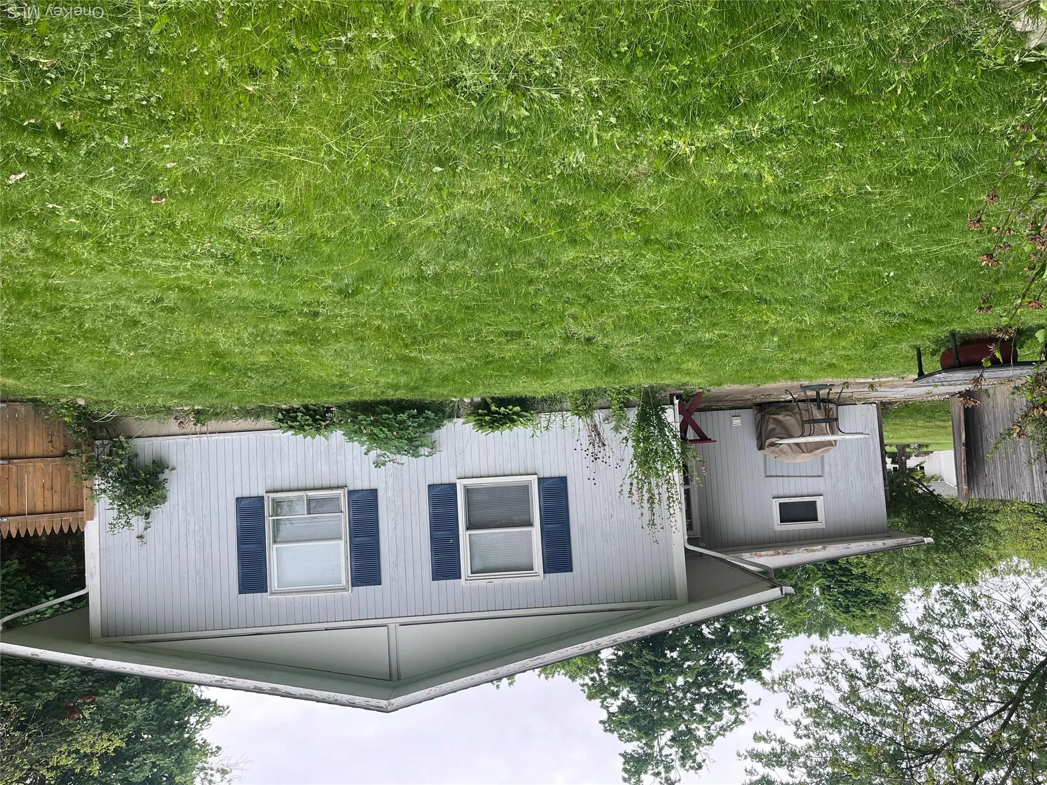 Expansive rear yard featuring green lawn, mature trees, and a wooden privacy fence Expansive rear yard featuring green lawn, mature trees, and a wooden privacy fence