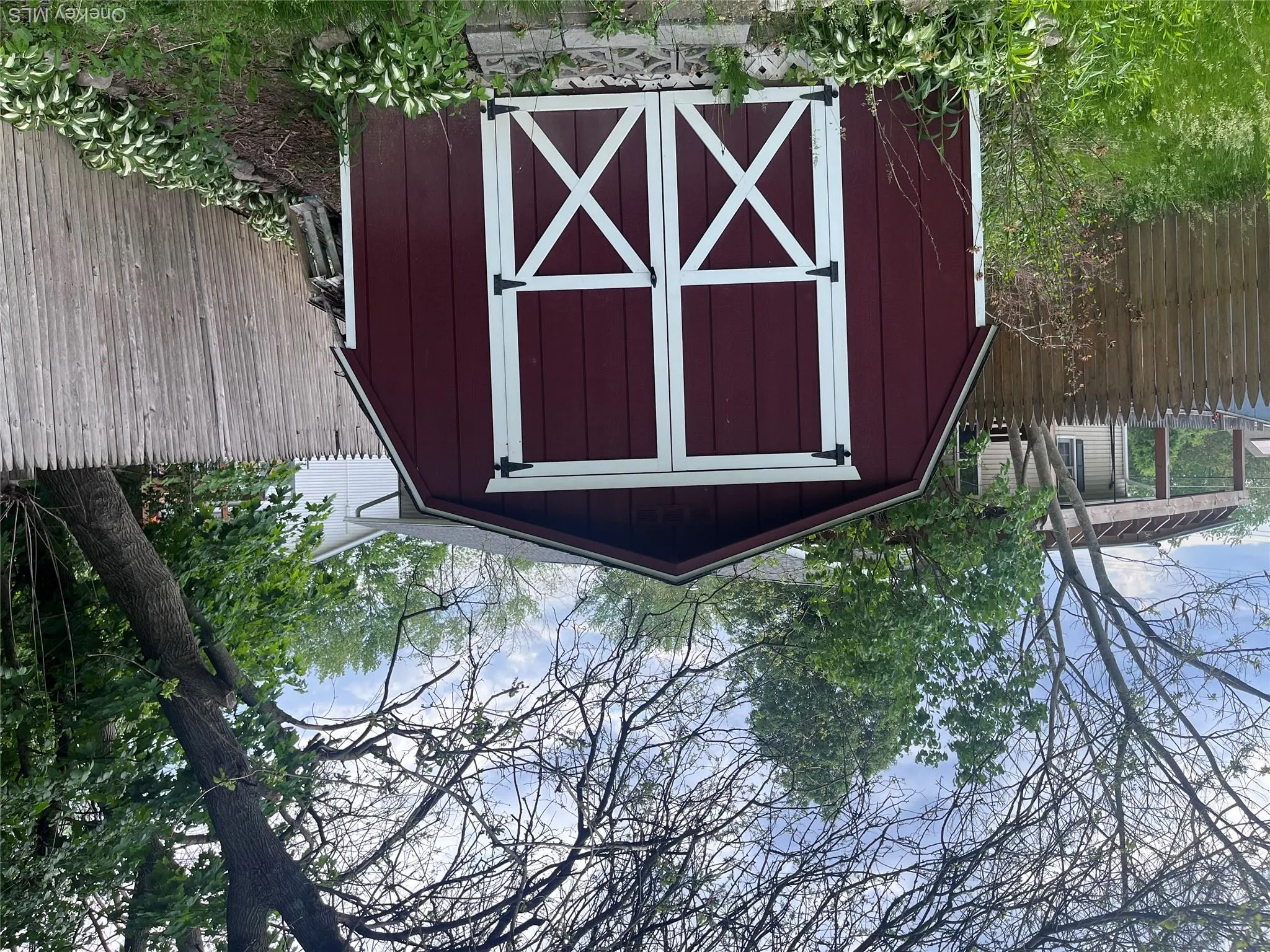 Red barn-style shed with white trim and crossbuck doors Red barn-style shed with white trim and crossbuck doors