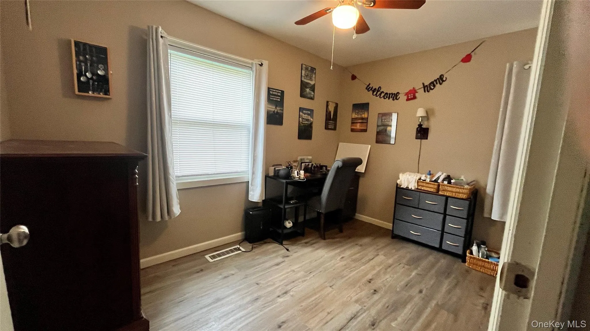 Bedroom featuring wood-finish flooring, a ceiling fan, and a window with blinds Bedroom featuring wood-finish flooring, a ceiling fan, and a window with blinds