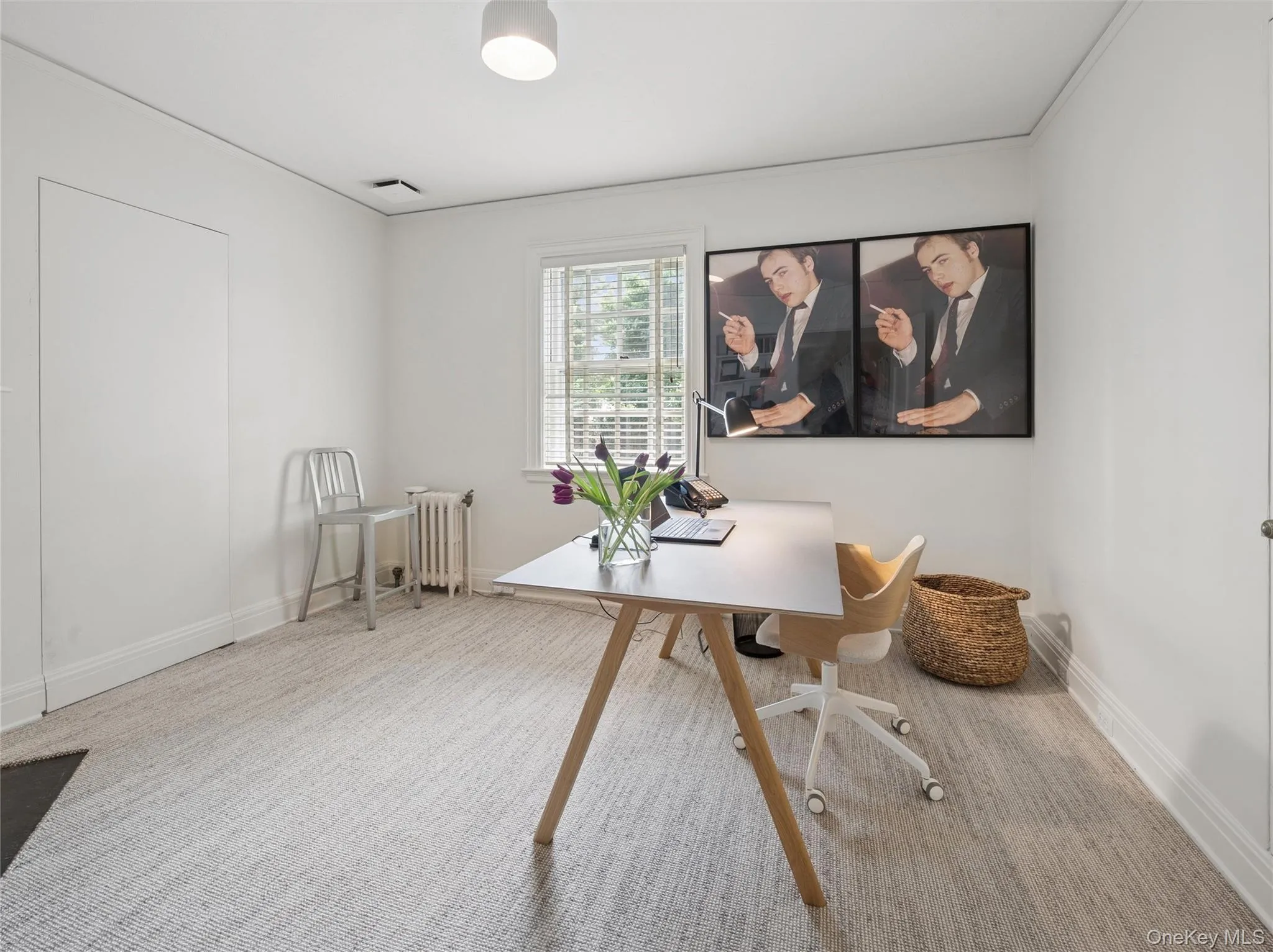 Bright office featuring a window with white blinds, neutral wall paint, and textured flooring Bright office featuring a window with white blinds, neutral wall paint, and textured flooring
