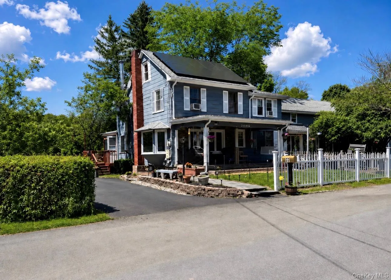 Two-story residence featuring light blue siding, white trim, and a covered front porch Two-story residence featuring light blue siding, white trim, and a covered front porch