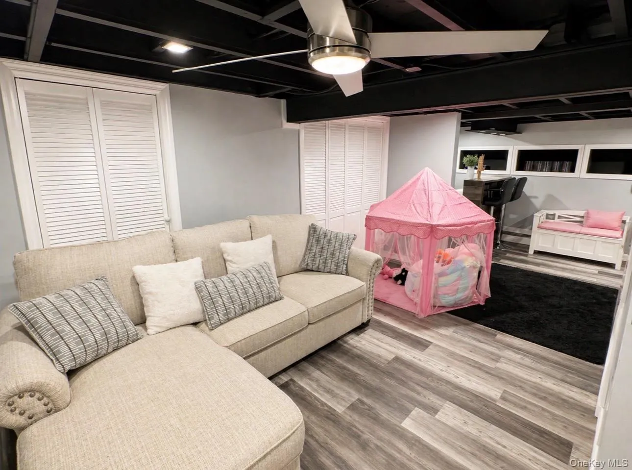 Finished lower level featuring wood-finish flooring, a contemporary ceiling fan, and recessed lighting Finished lower level featuring wood-finish flooring, a contemporary ceiling fan, and recessed lighting