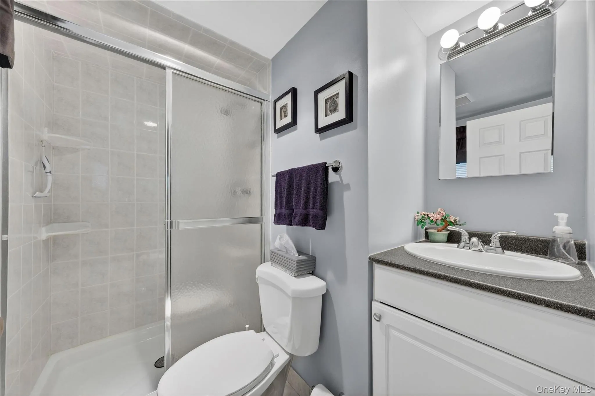 Primary Bathroom featuring a tiled shower with sliding glass doors Primary Bathroom featuring a tiled shower with sliding glass doors