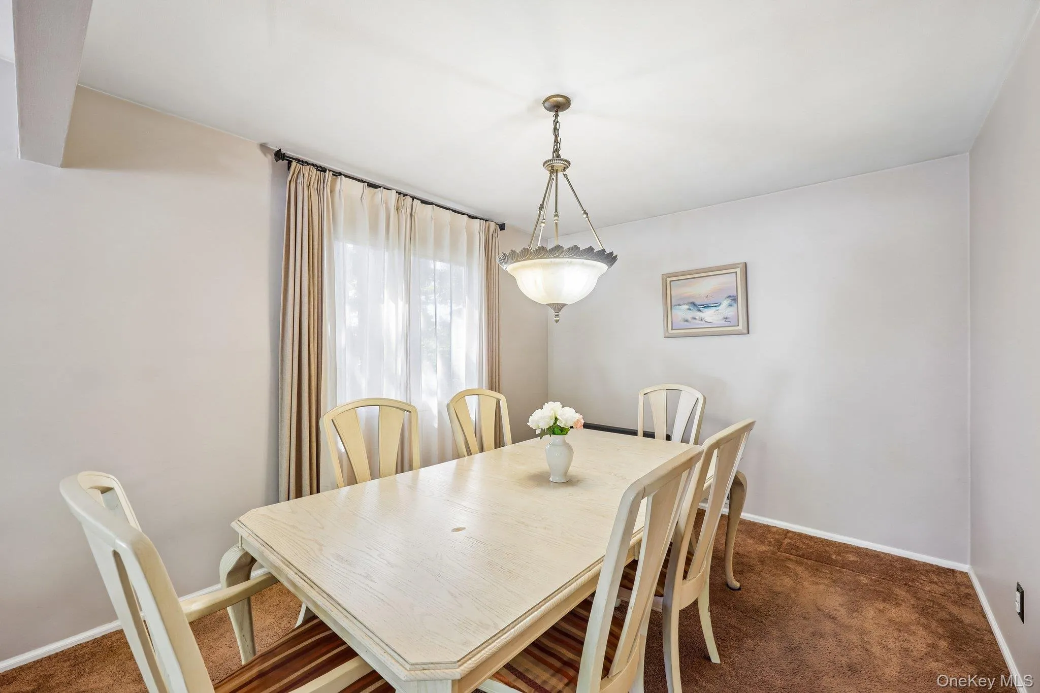 Dining room featuring carpet over wood flooring, window and a pendant light fixture Dining room featuring carpet over wood flooring, window and a pendant light fixture