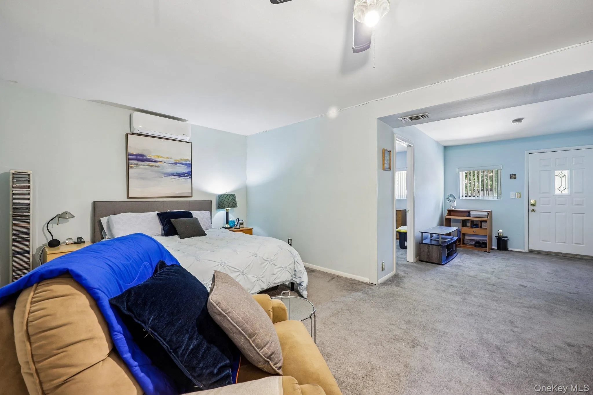 Lower Living rm/Bedroom, part of garage conversion with light blue walls, large closet, and front entrance to outside. Lower Living rm/Bedroom, part of garage conversion with light blue walls, large closet, and front entrance to outside.