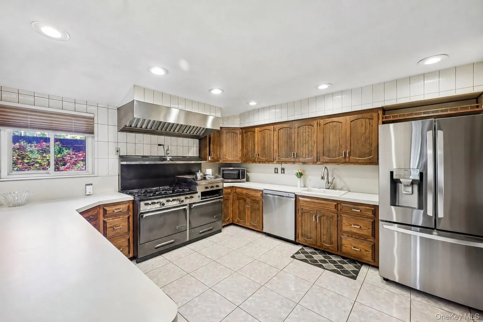 Eat-In-Kitchen, Dining Room view, featuring wood cabinetry, high hats, lots of counter space window to yard, tile flooring, stainless appliances including large gas range with professional grade hood Eat-In-Kitchen, Dining Room view, featuring wood cabinetry, high hats, lots of counter space window to yard, tile flooring, stainless appliances including large gas range with professional grade hood