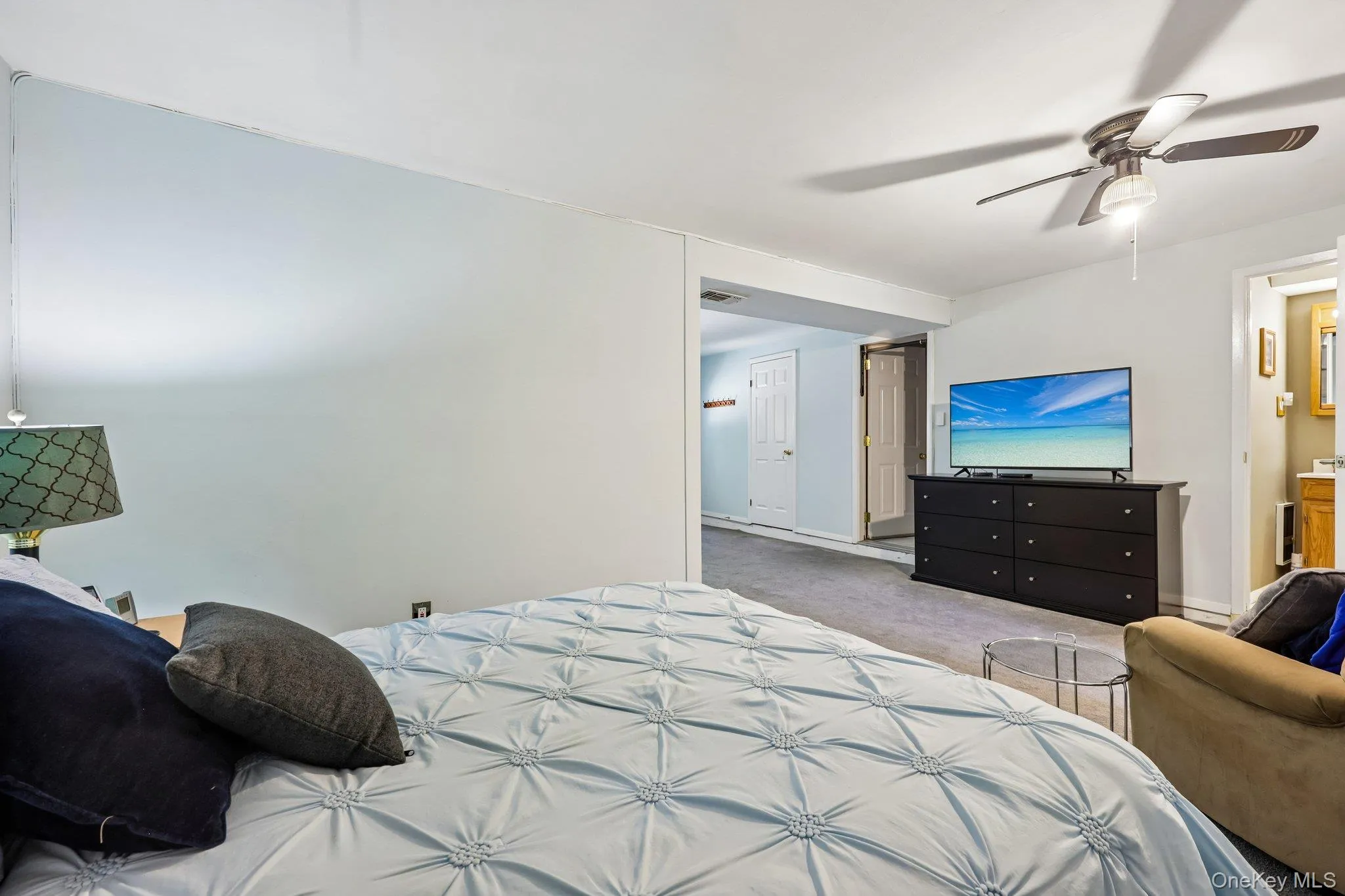 Bedroom/living area, part of the legal garage conversion with light blue walls and a ceiling fan. Split air conditioner newly installed. Bedroom/living area, part of the legal garage conversion with light blue walls and a ceiling fan. Split air conditioner newly installed.