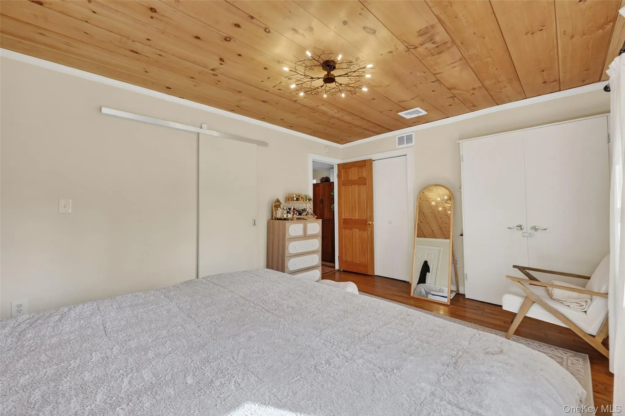 Warm wood-finish ceiling featuring a unique branch-inspired light fixture Warm wood-finish ceiling featuring a unique branch-inspired light fixture