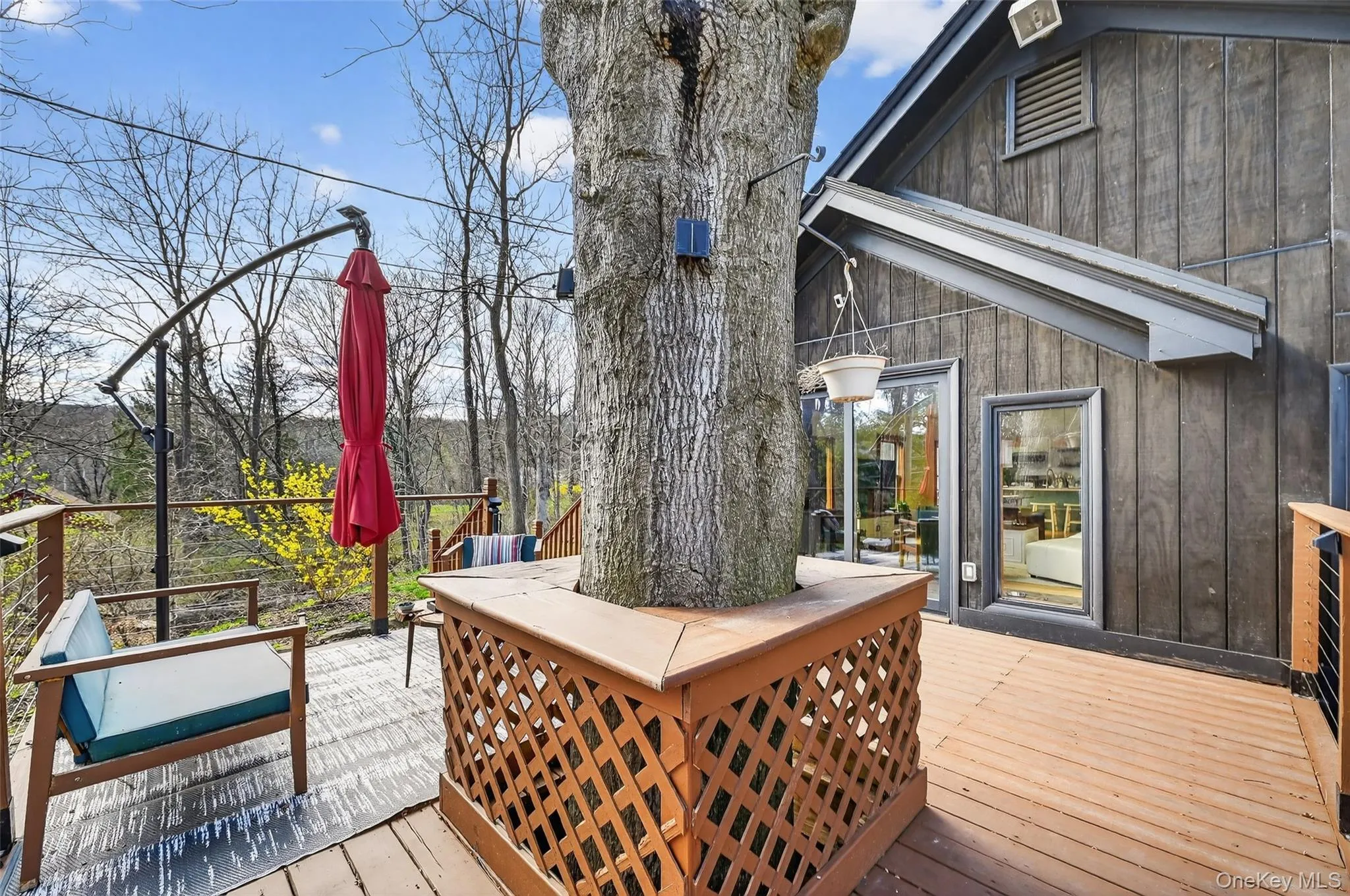 Expansive wood-finish deck with a built-in tree surround Expansive wood-finish deck with a built-in tree surround