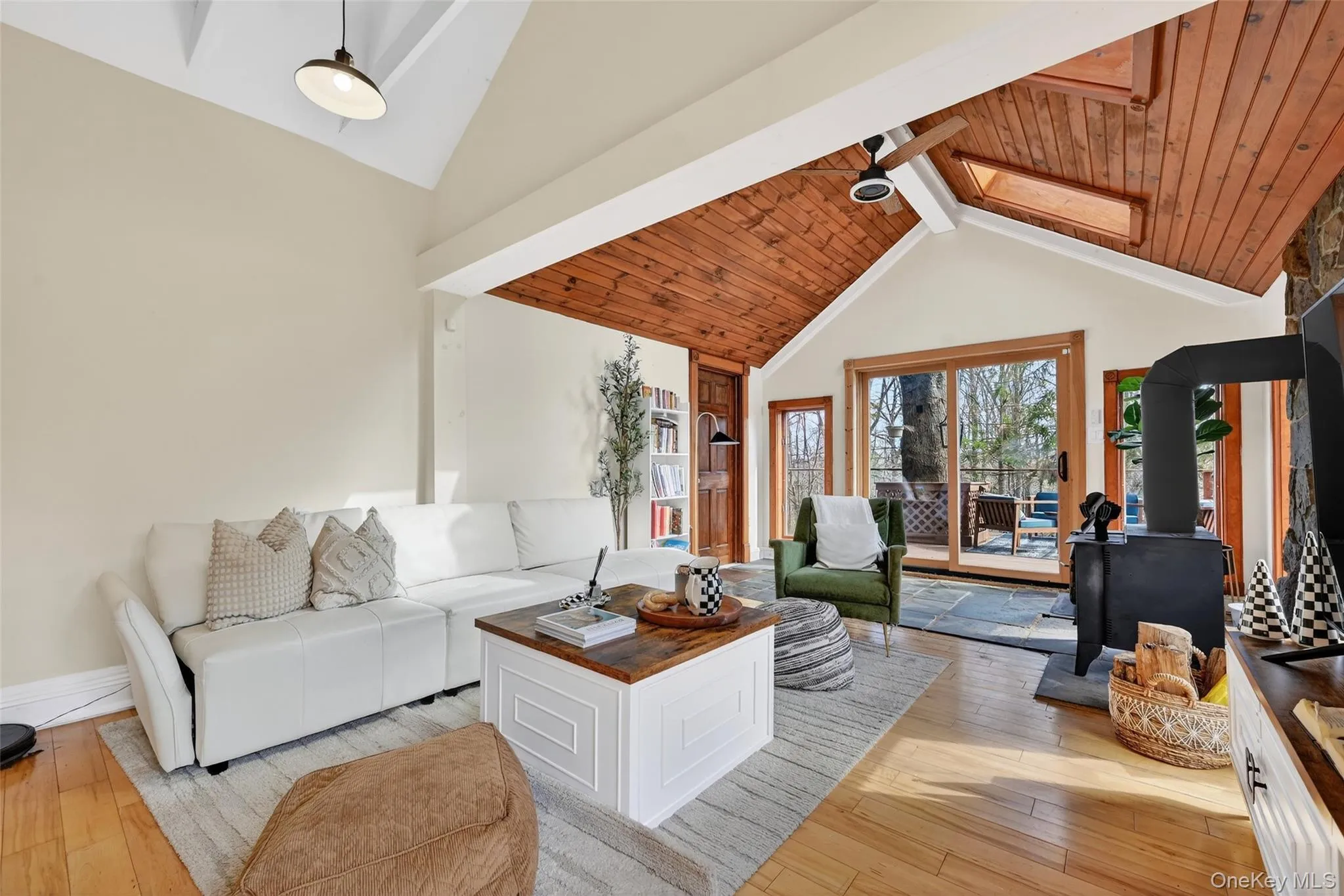 Vaulted wood-paneled ceilings with exposed beams and a skylight define this living space Vaulted wood-paneled ceilings with exposed beams and a skylight define this living space