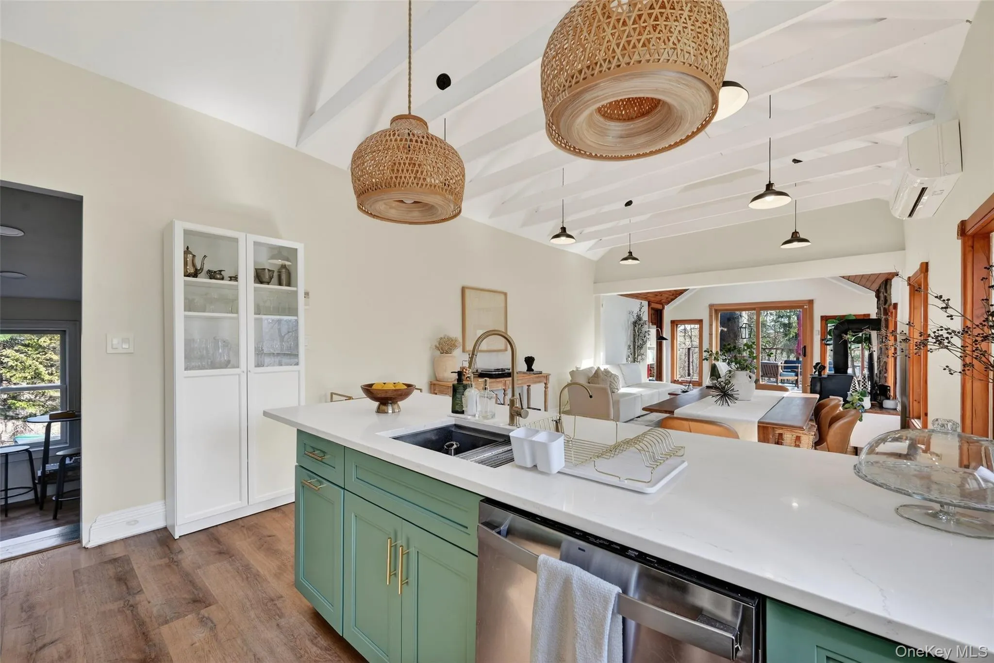 Kitchen island featuring green cabinetry, a white countertop, and an undermount sink with a gooseneck faucet Kitchen island featuring green cabinetry, a white countertop, and an undermount sink with a gooseneck faucet
