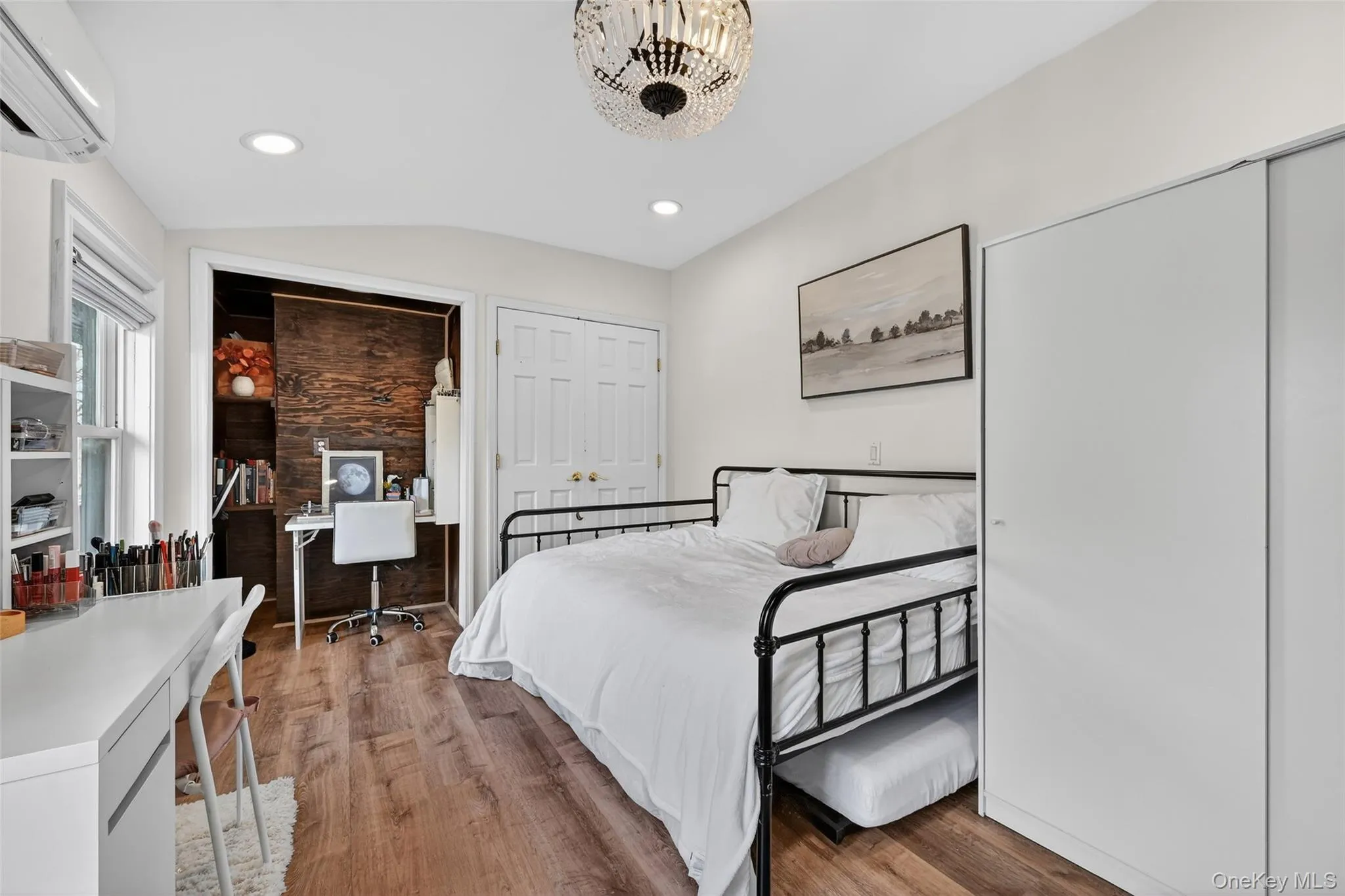 Bedroom with wood-finish flooring, recessed lighting, and a contemporary ceiling fixture Bedroom with wood-finish flooring, recessed lighting, and a contemporary ceiling fixture