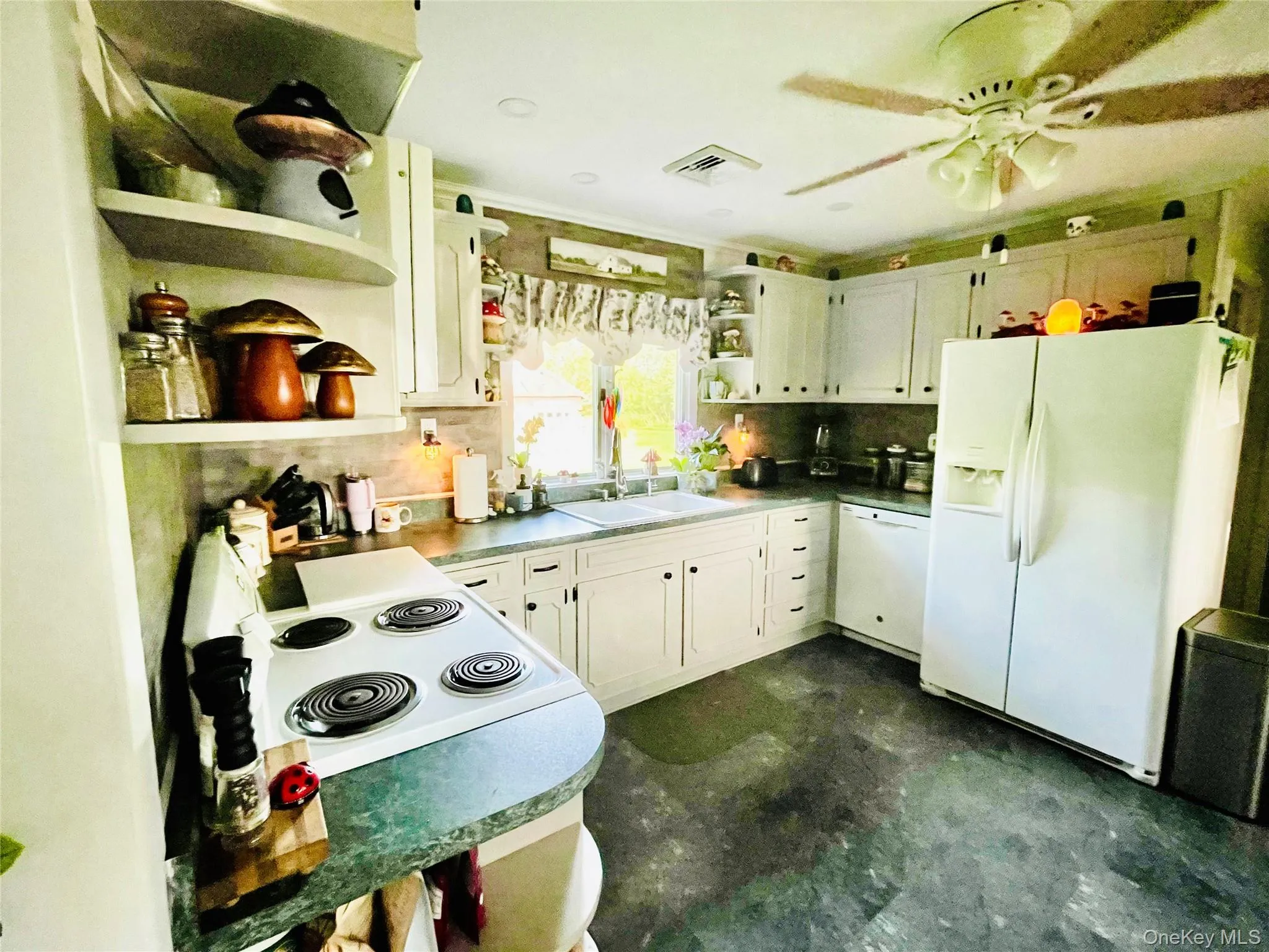 Gas stove, refrigerator, grey cabinetry and vinyl tile flooring. Gas stove, refrigerator, grey cabinetry and vinyl tile flooring.
